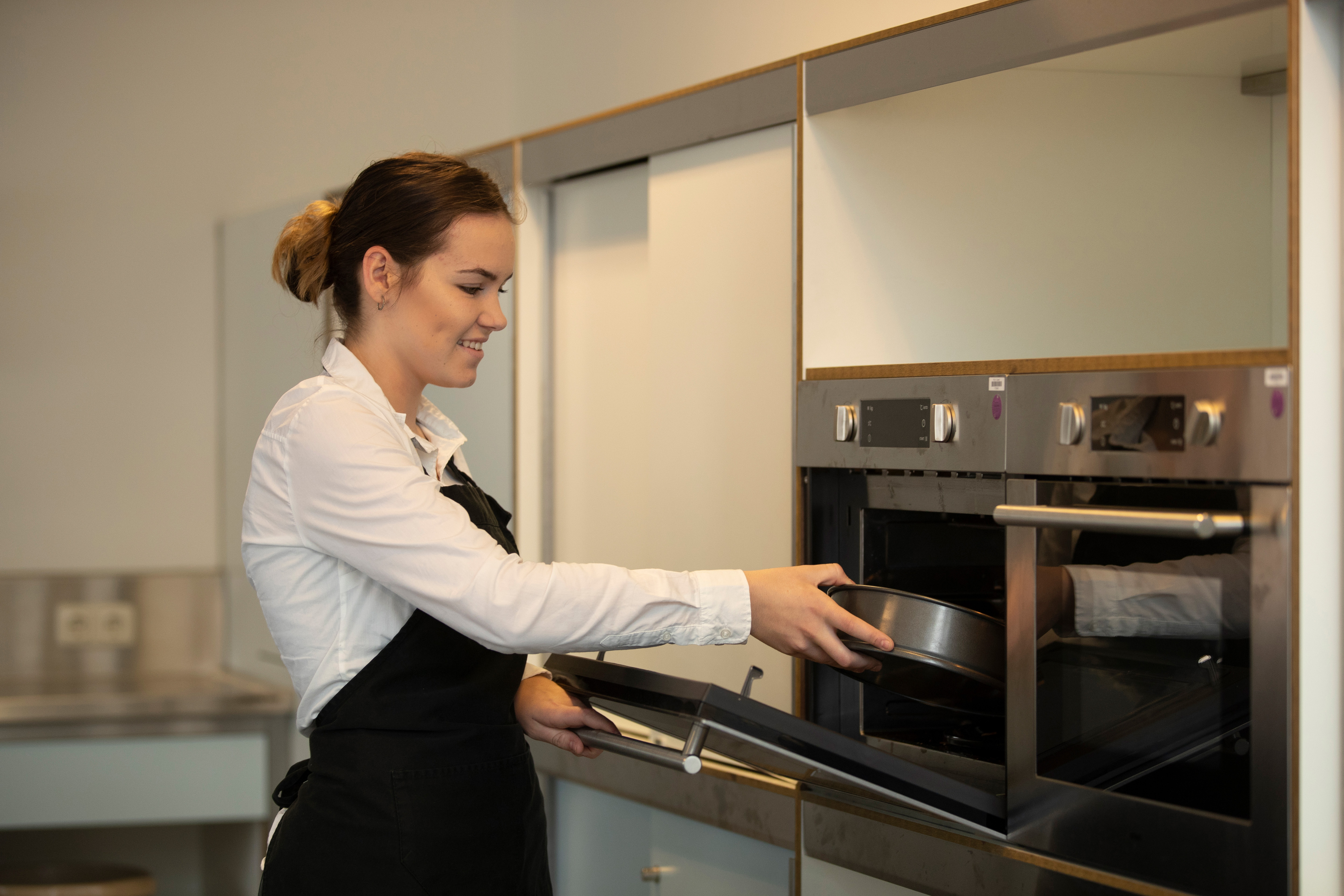 Student doet iets in de oven