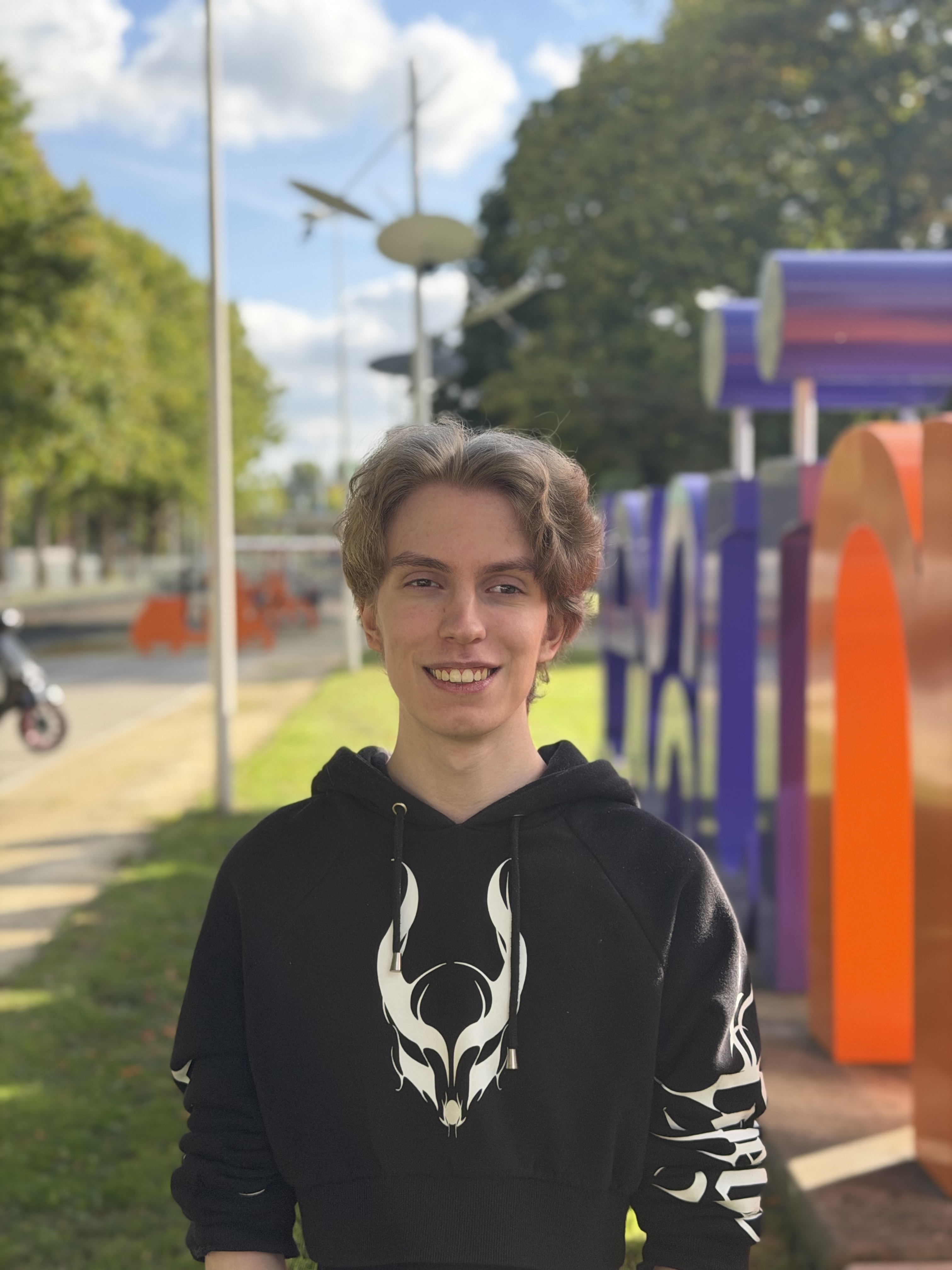 Jongen kijkt in de camera terwijl hij voor het Rijn IJssel logo staat