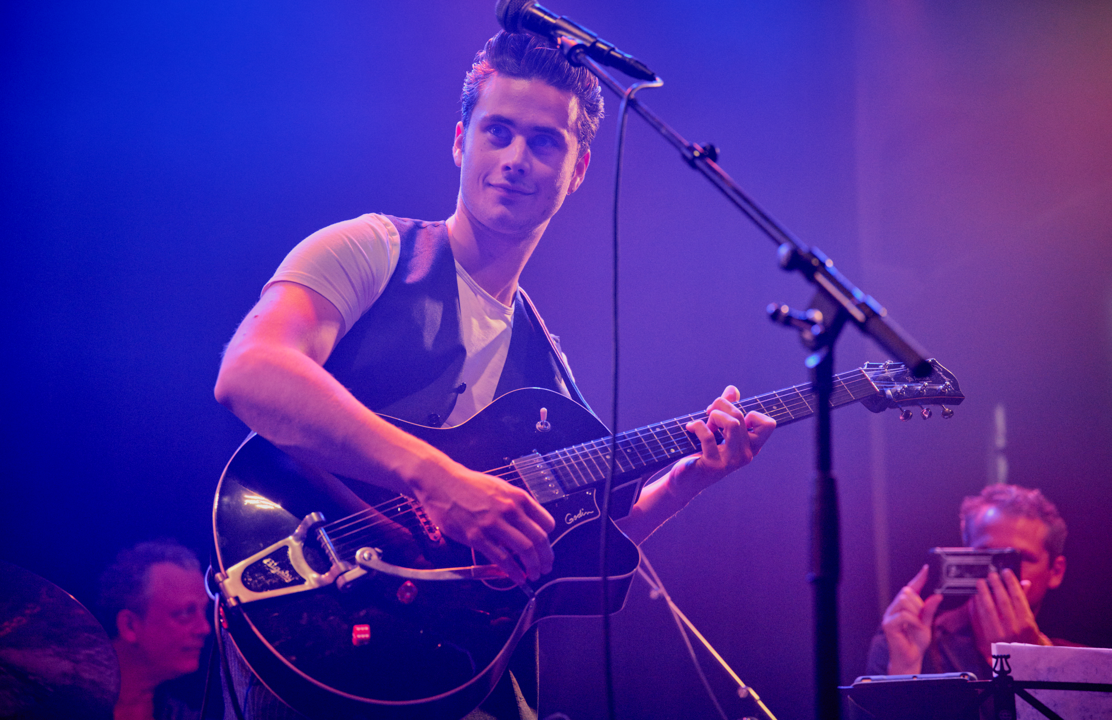 Een jongen speelt gitaar en de andere jongen is aan het drummen