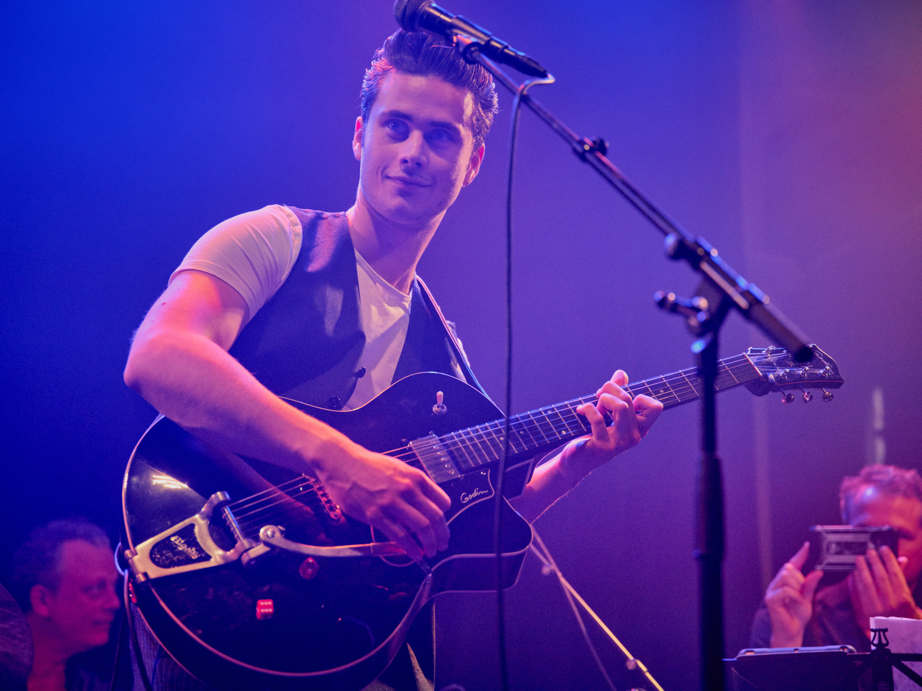 Een jongen speelt gitaar en de andere jongen is aan het drummen