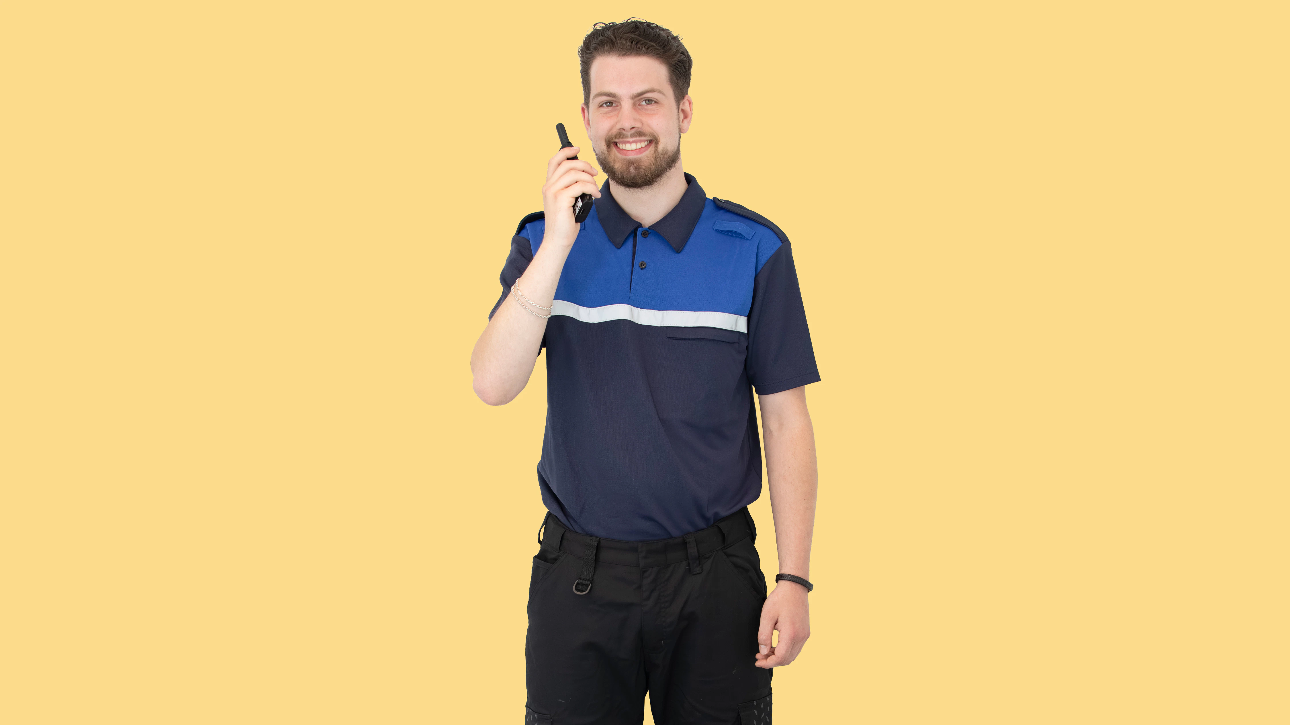 Jongen in beveiligers kleding poseert voor de camera terwijl hij in de Walkie Talkie praat