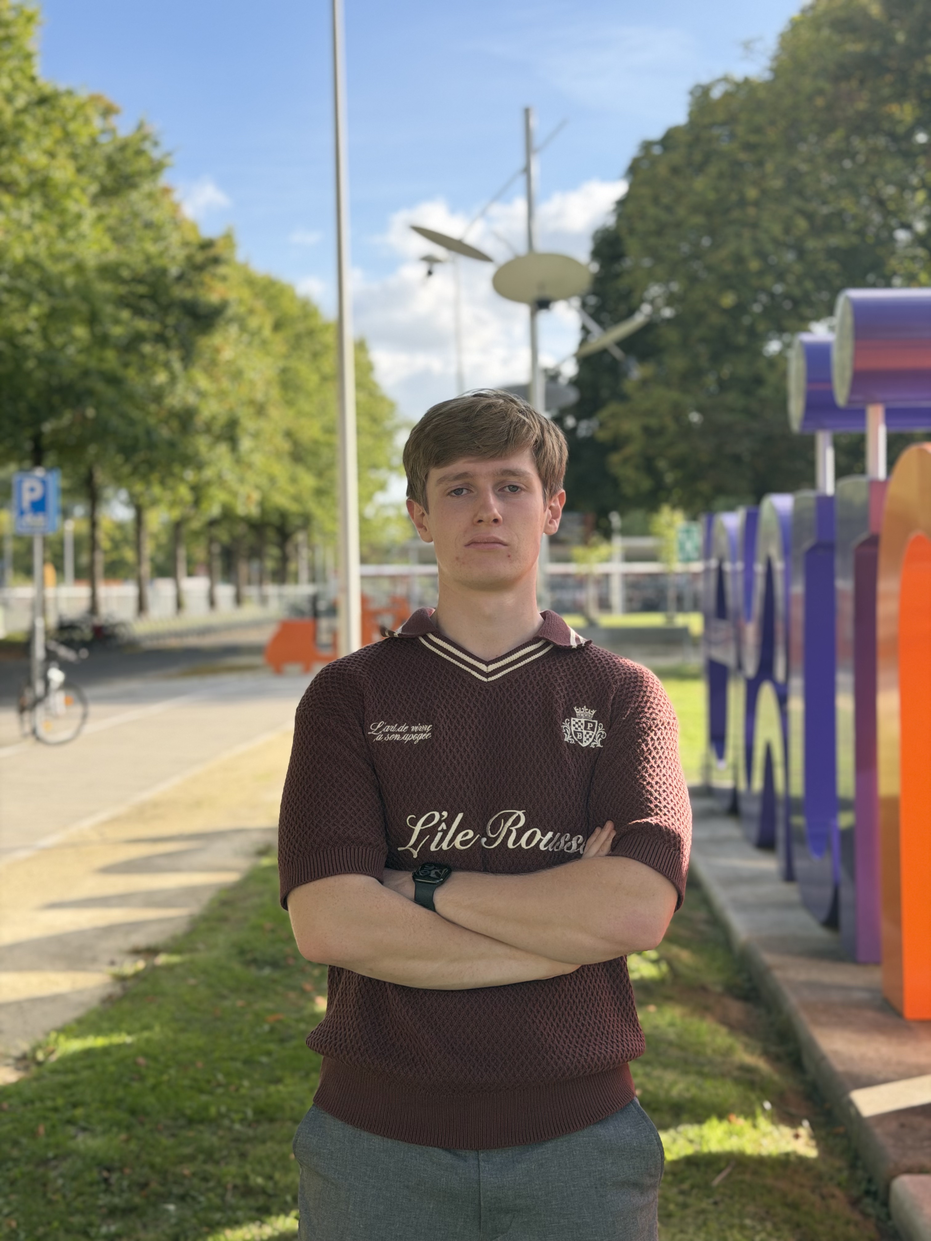 Jongen kijkt in de camera terwijl hij voor het Rijn IJssel logo staat