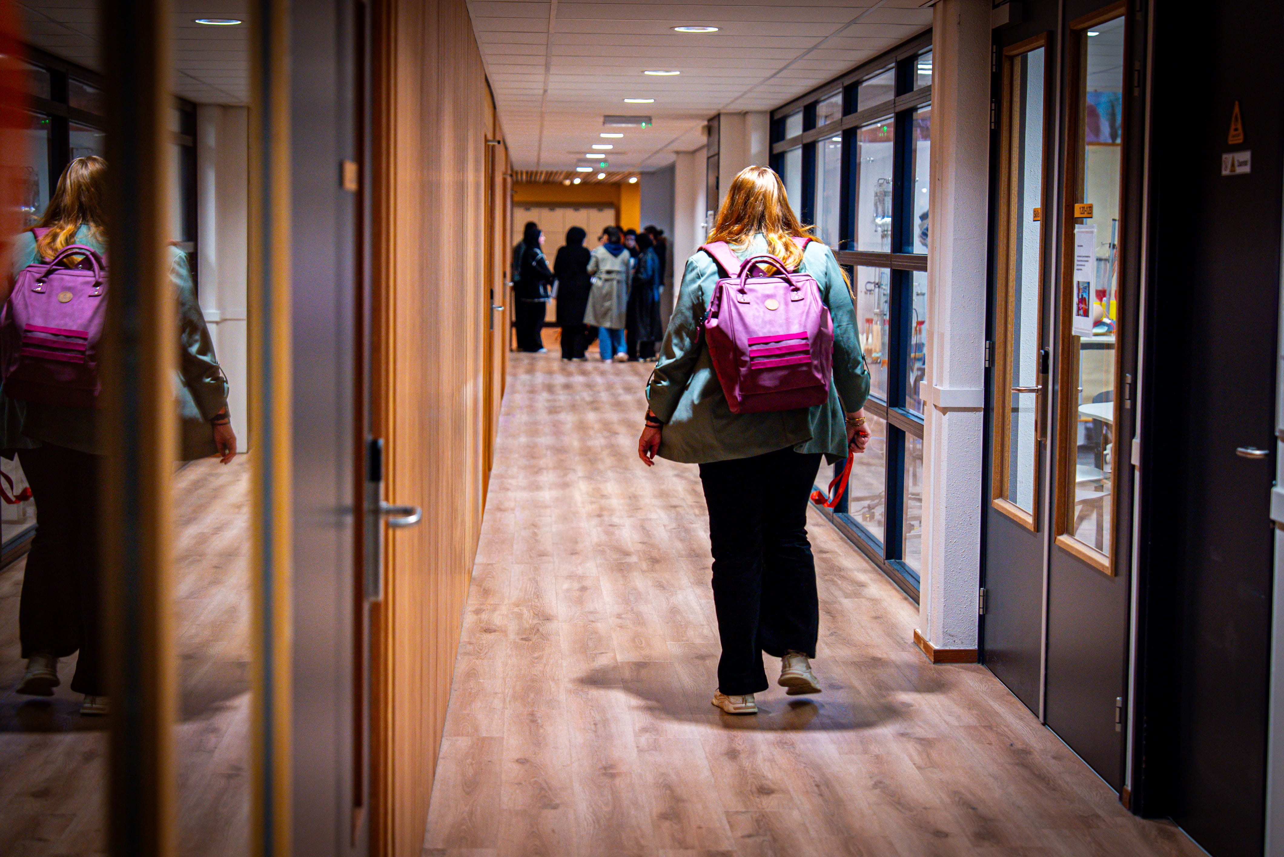 Een gang met studenten die naar hun lokaal lopen.