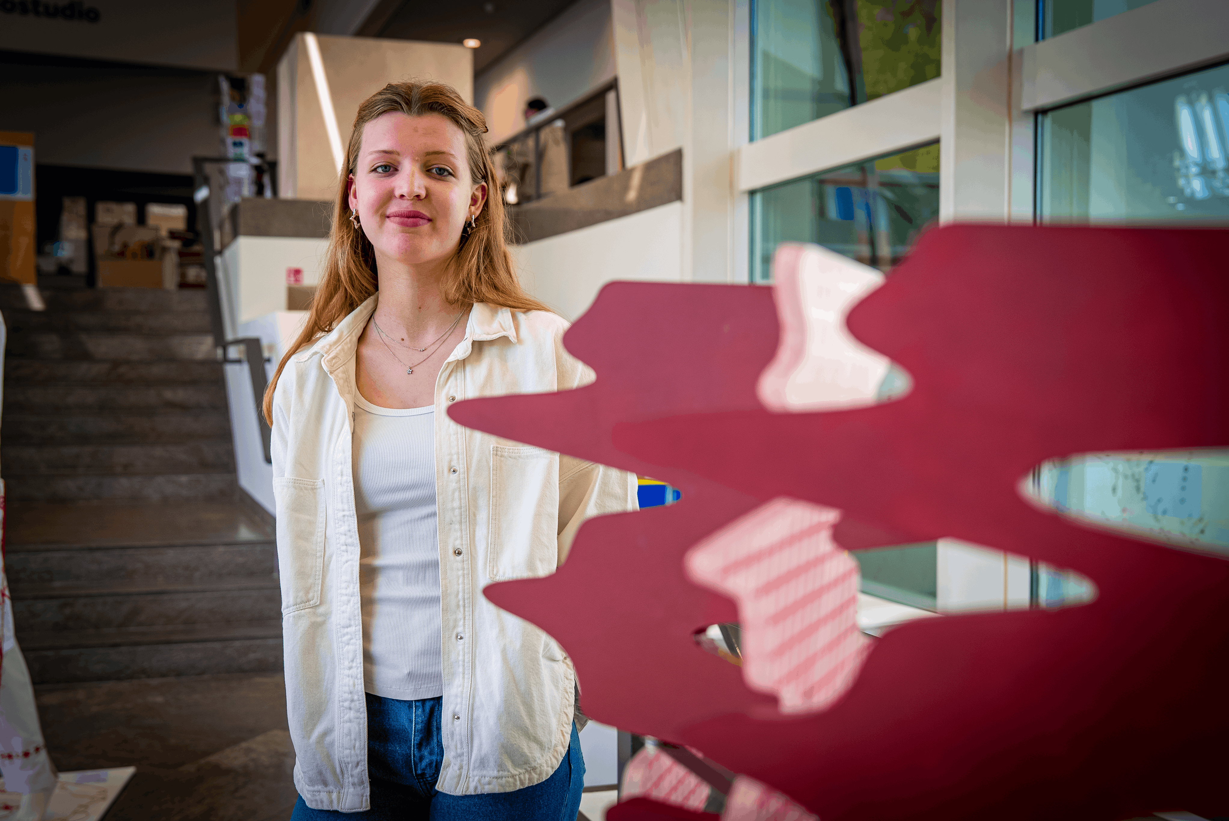 Meisje poseert voor de camera bij een kunsttentoonstelling.