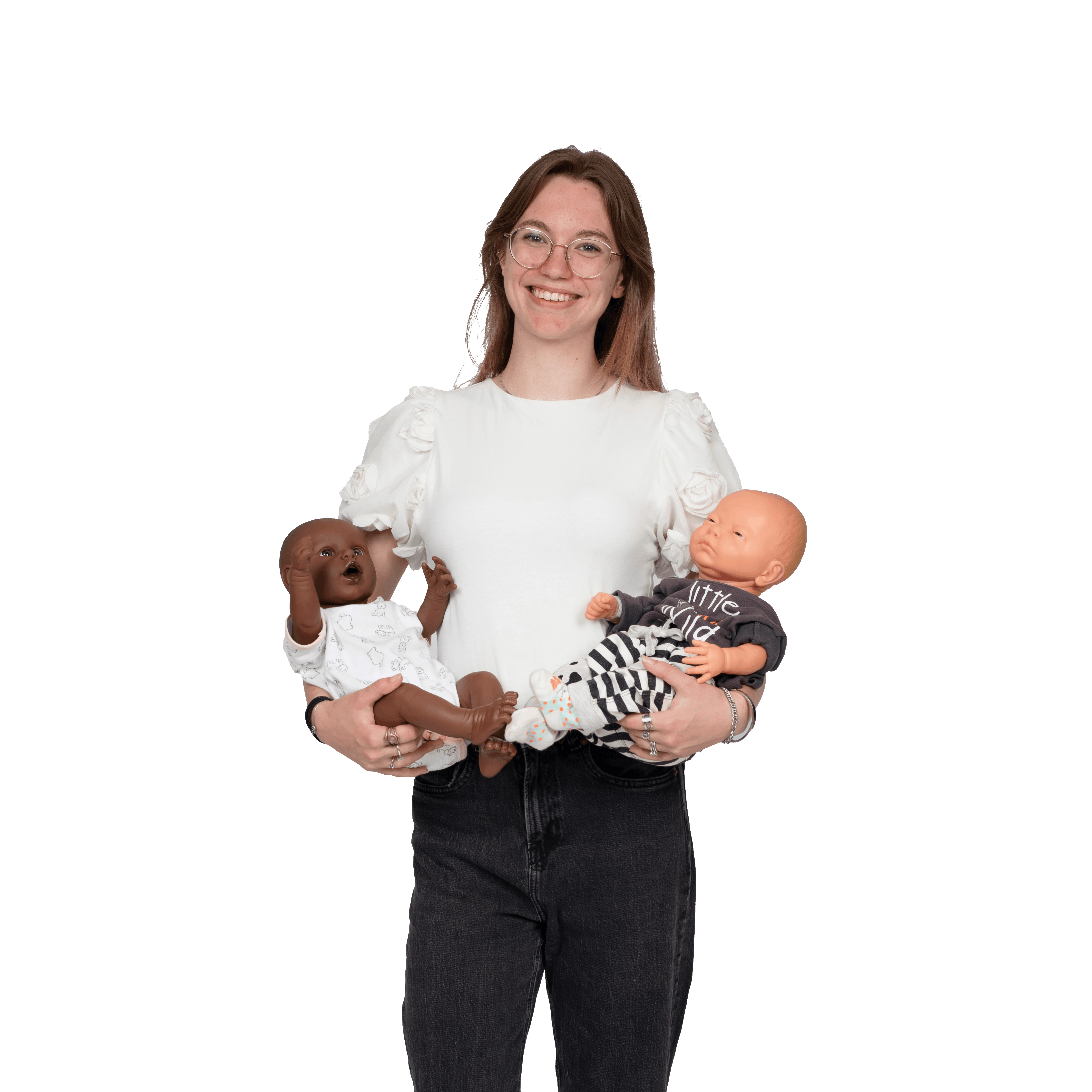 Een meisje met babypopen in haar armen poseert voor de camera.