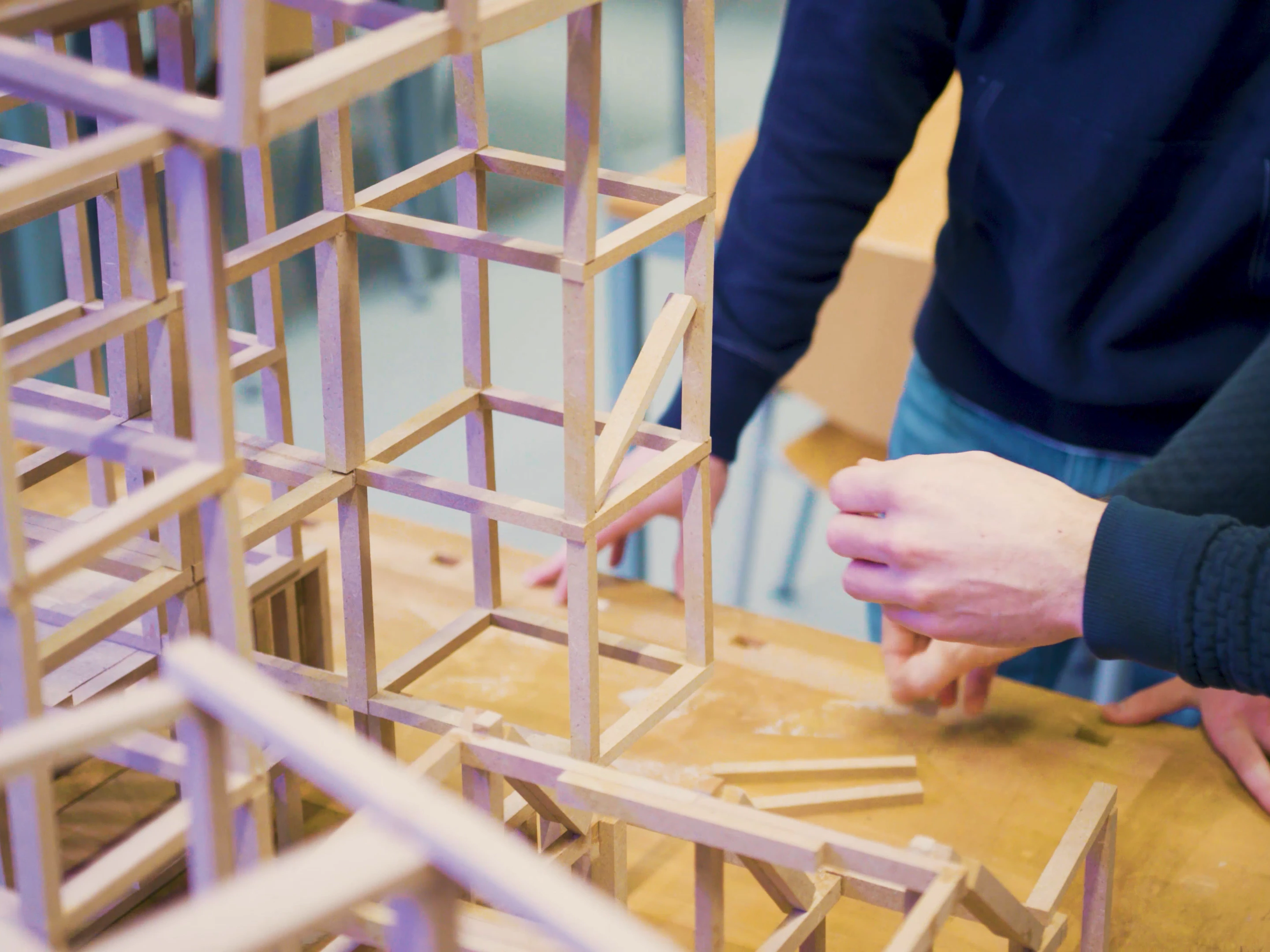 Student zit samen met een docent achter een computer