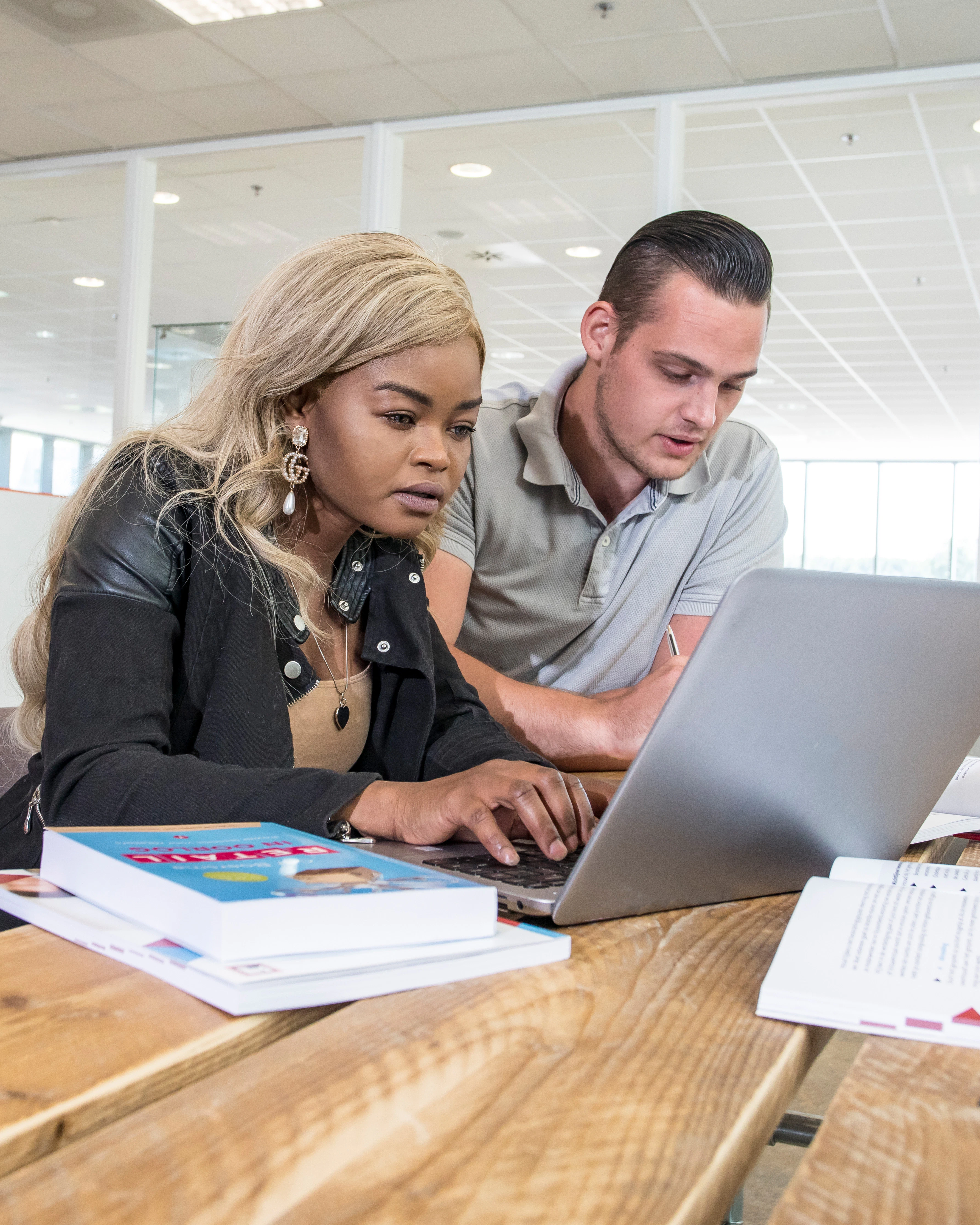 Twee studenten werken samen op laptop