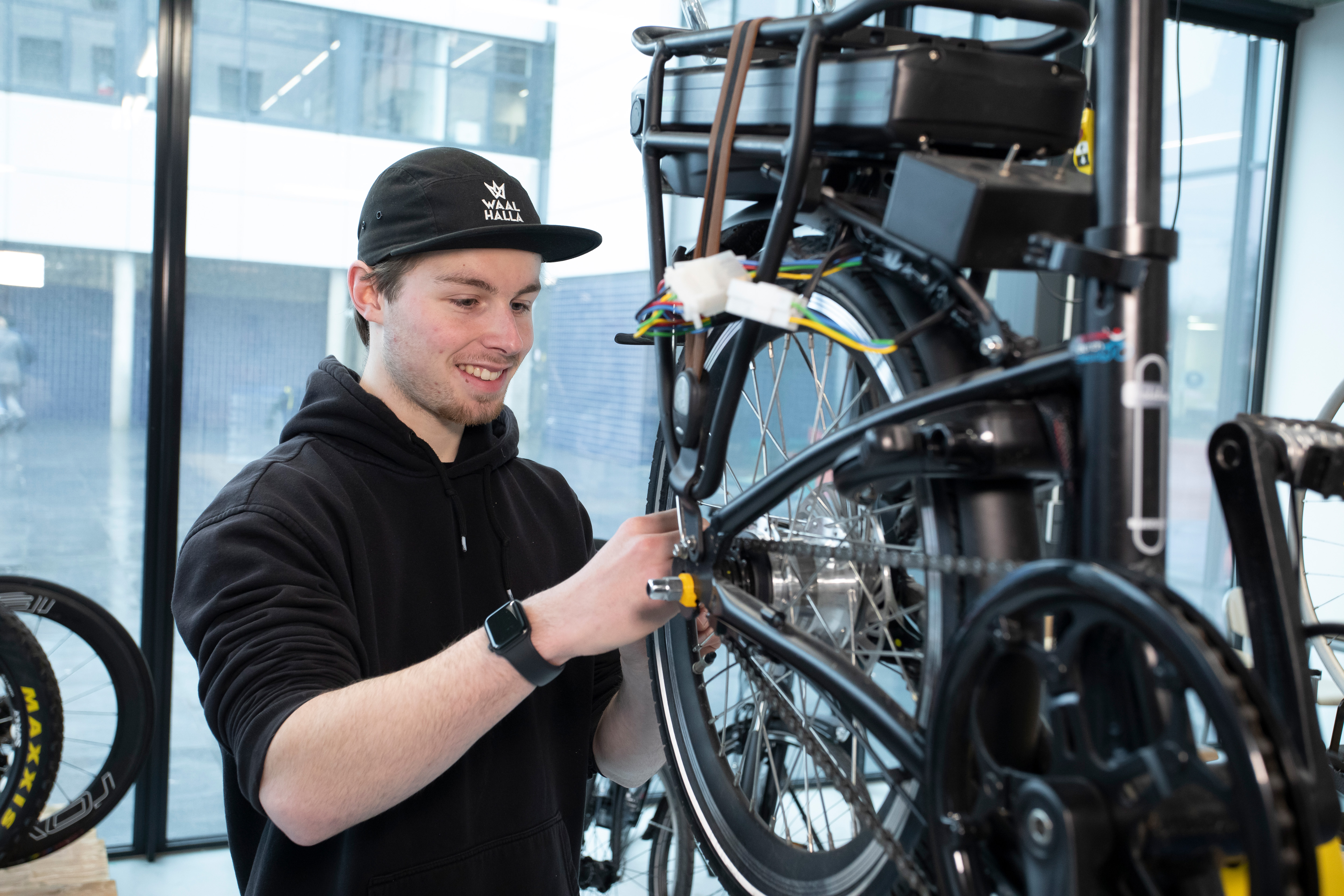 Student is bezig met het achterwiel van een fiets