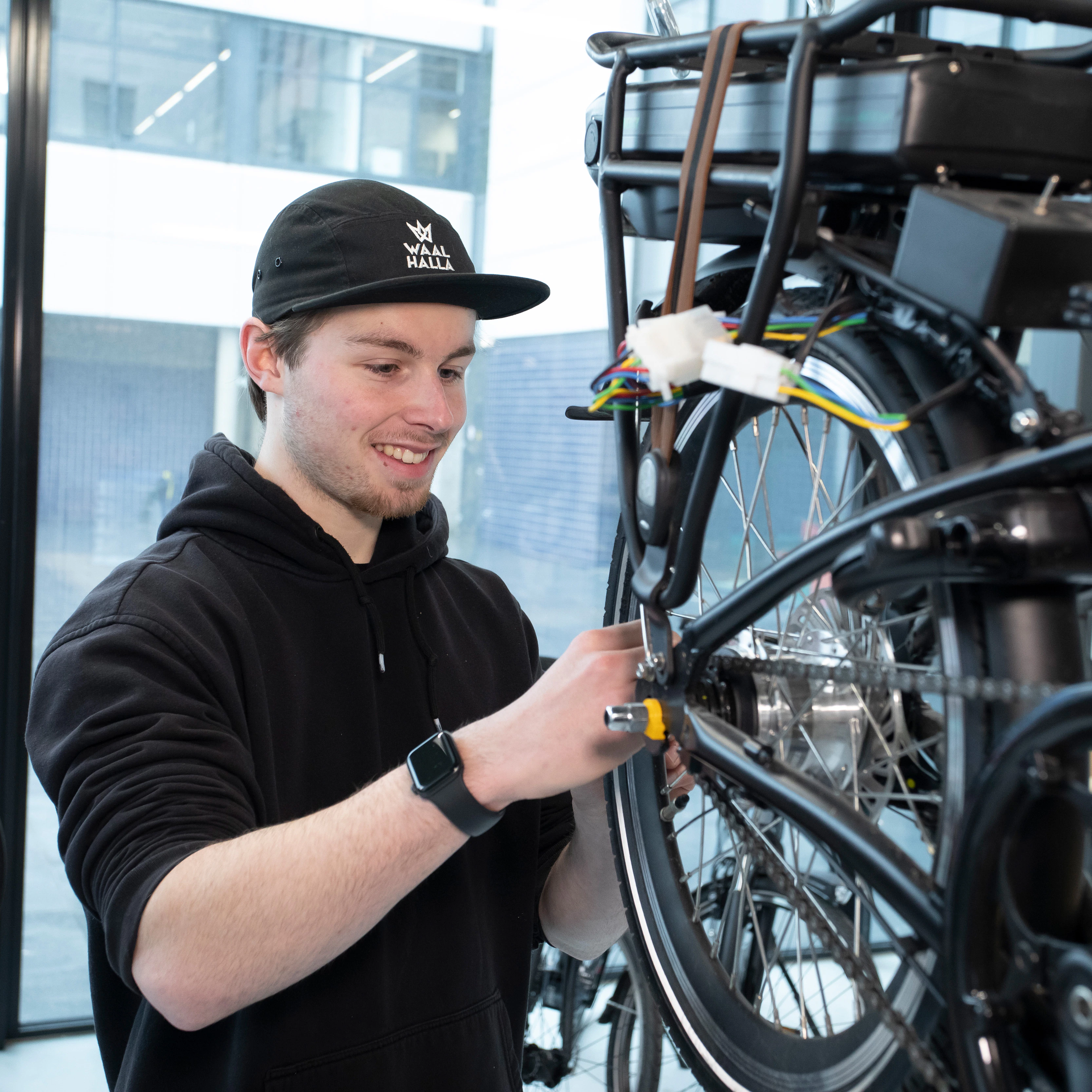 Student is bezig met het achterwiel van een fiets