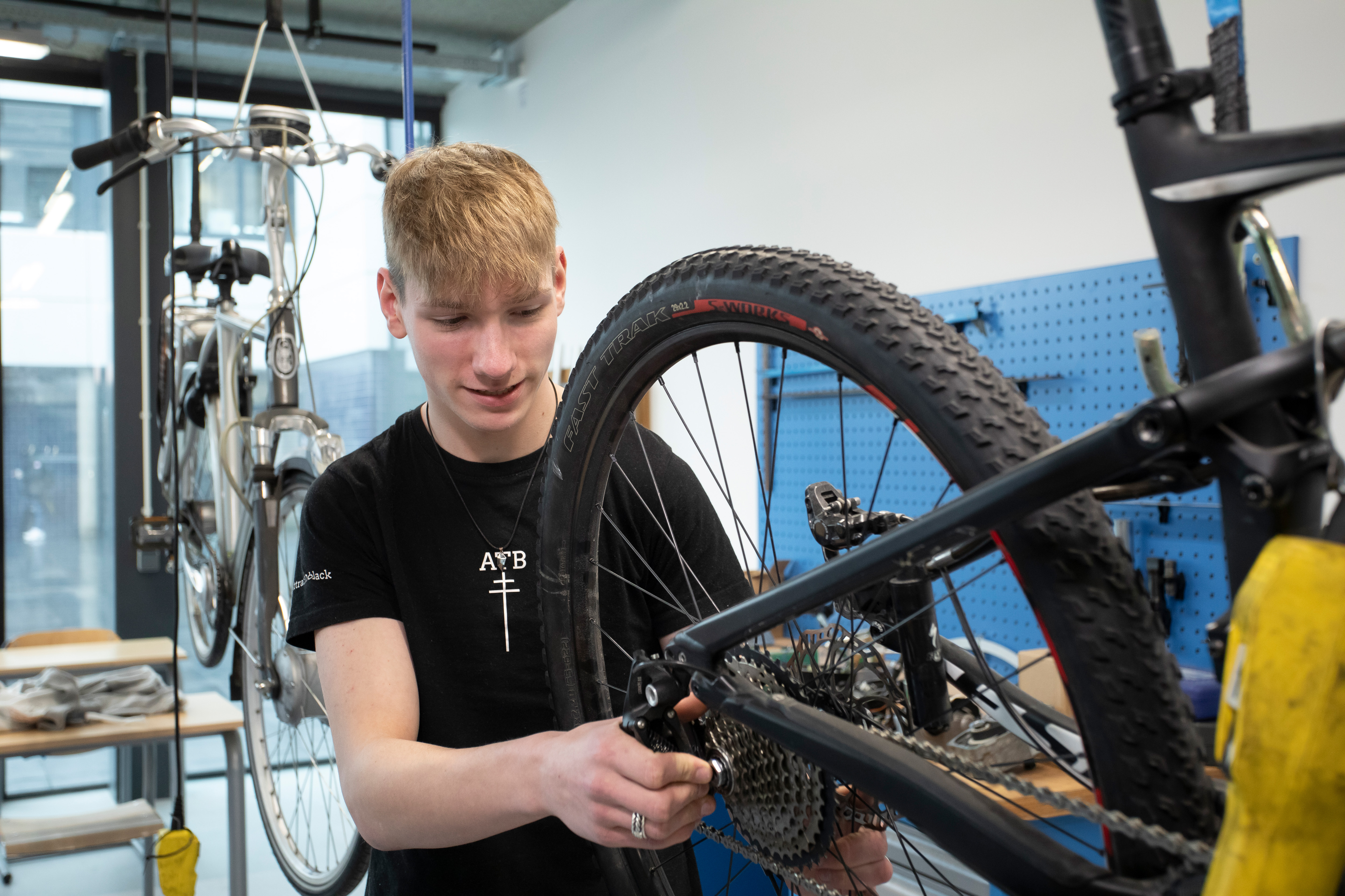 Student is bezig met het achterwiel van een fiets