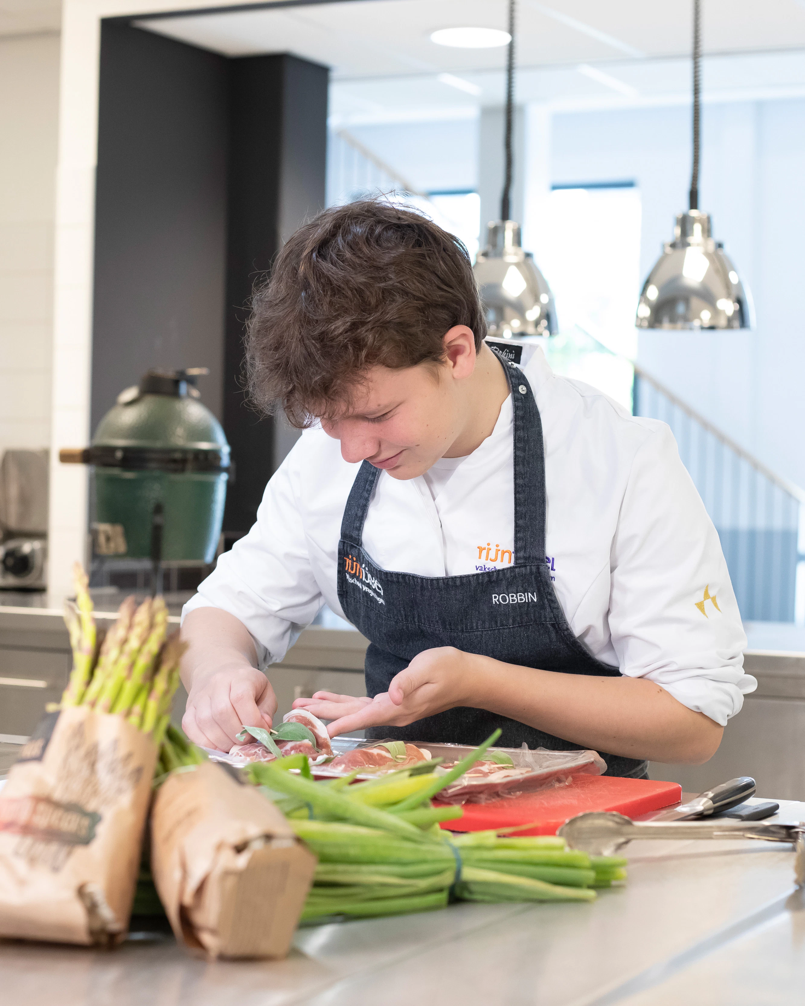 Jongen in kokskleding is een schaal eten aan het opmaken