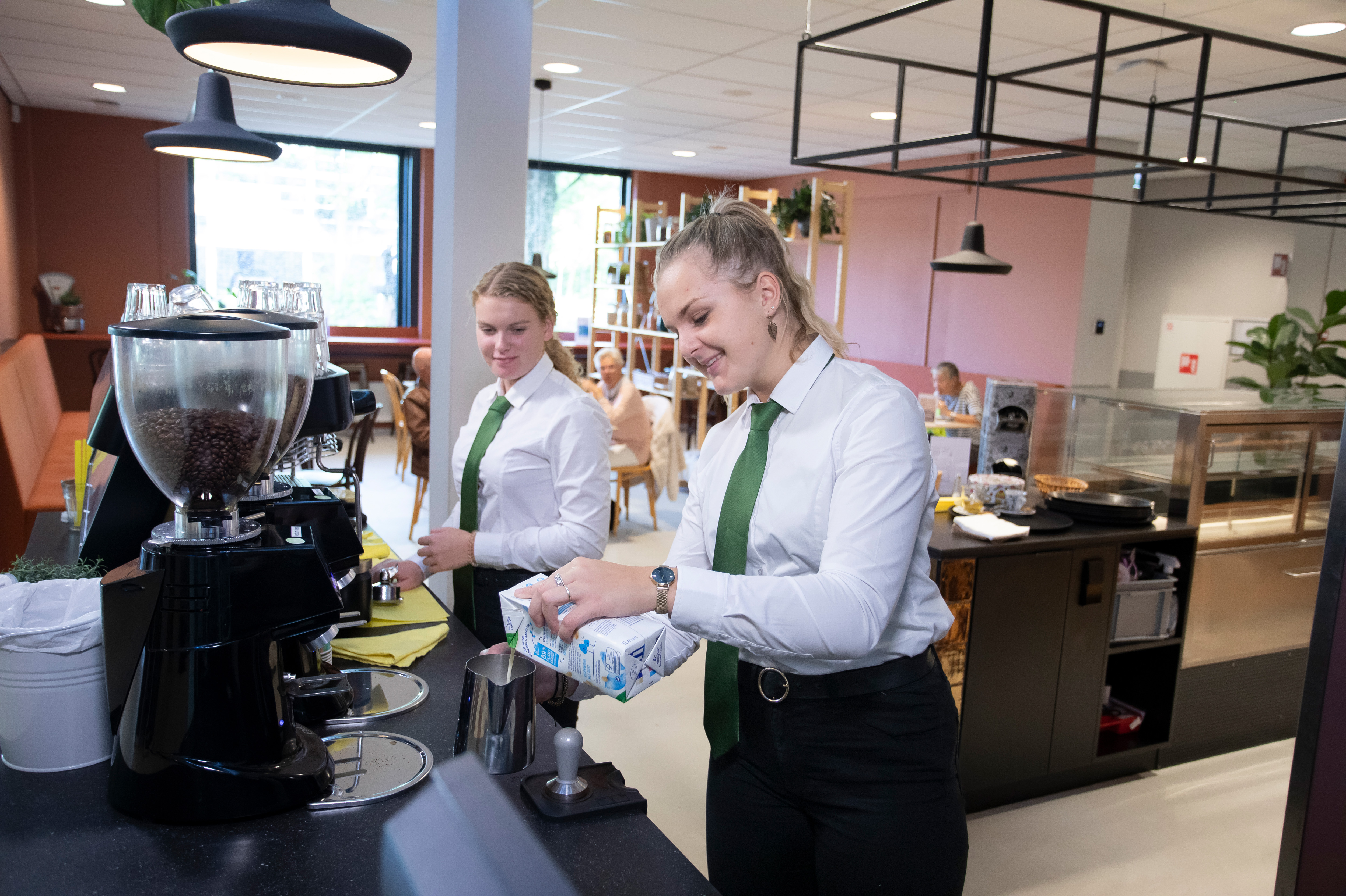 Twee meisje zijn bezig met koffie zetten