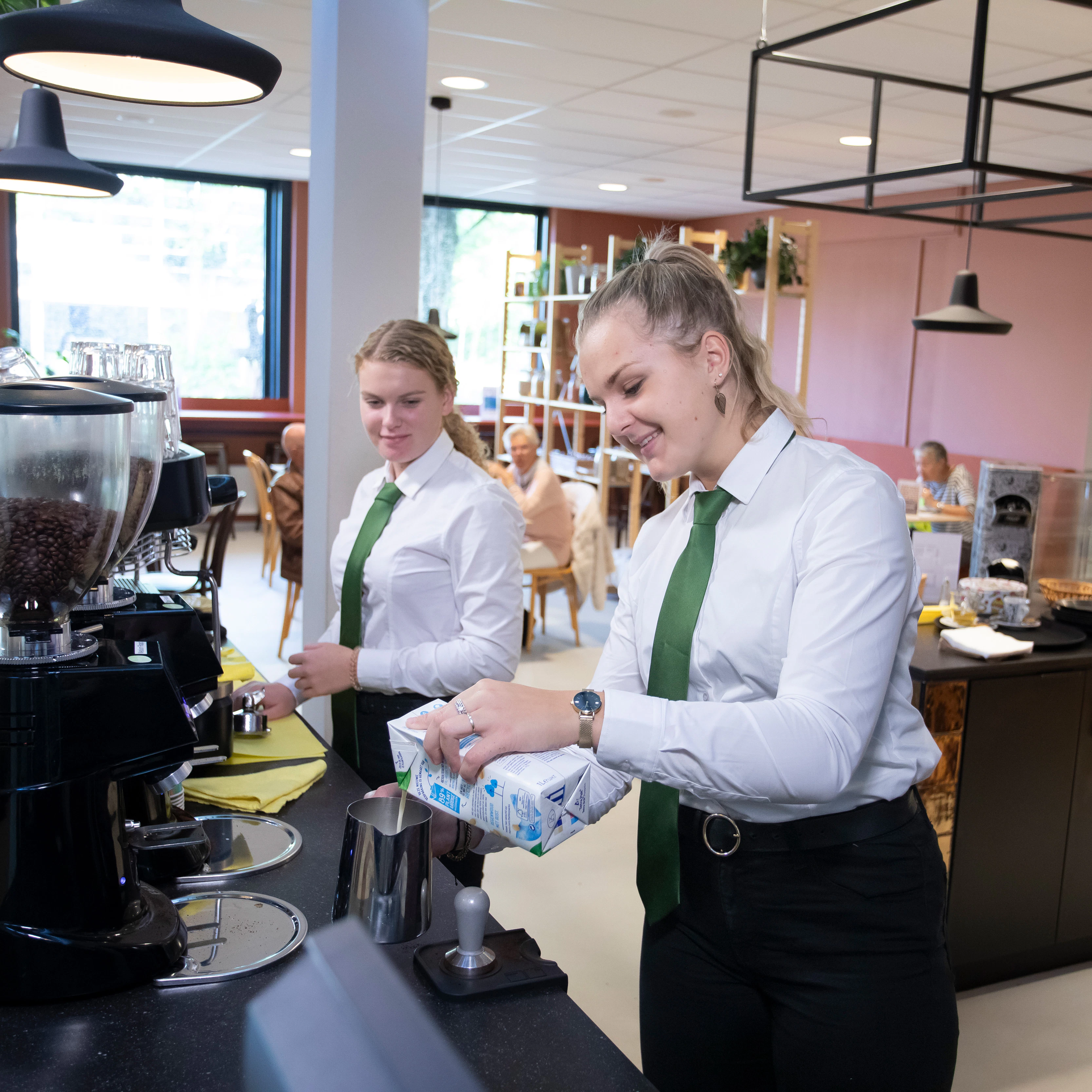 Twee meisje zijn bezig met koffie zetten