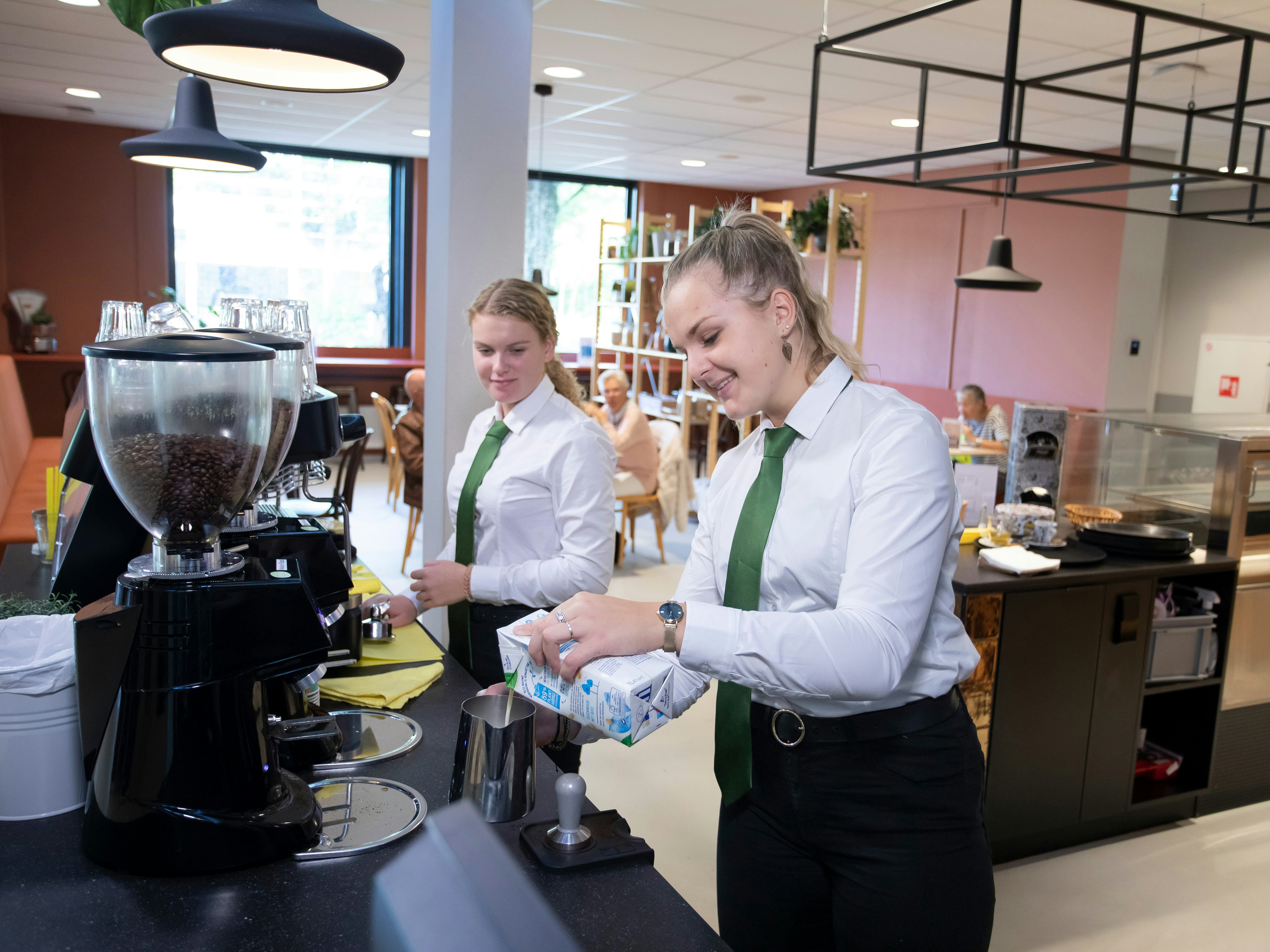 Twee meisje zijn bezig met koffie zetten