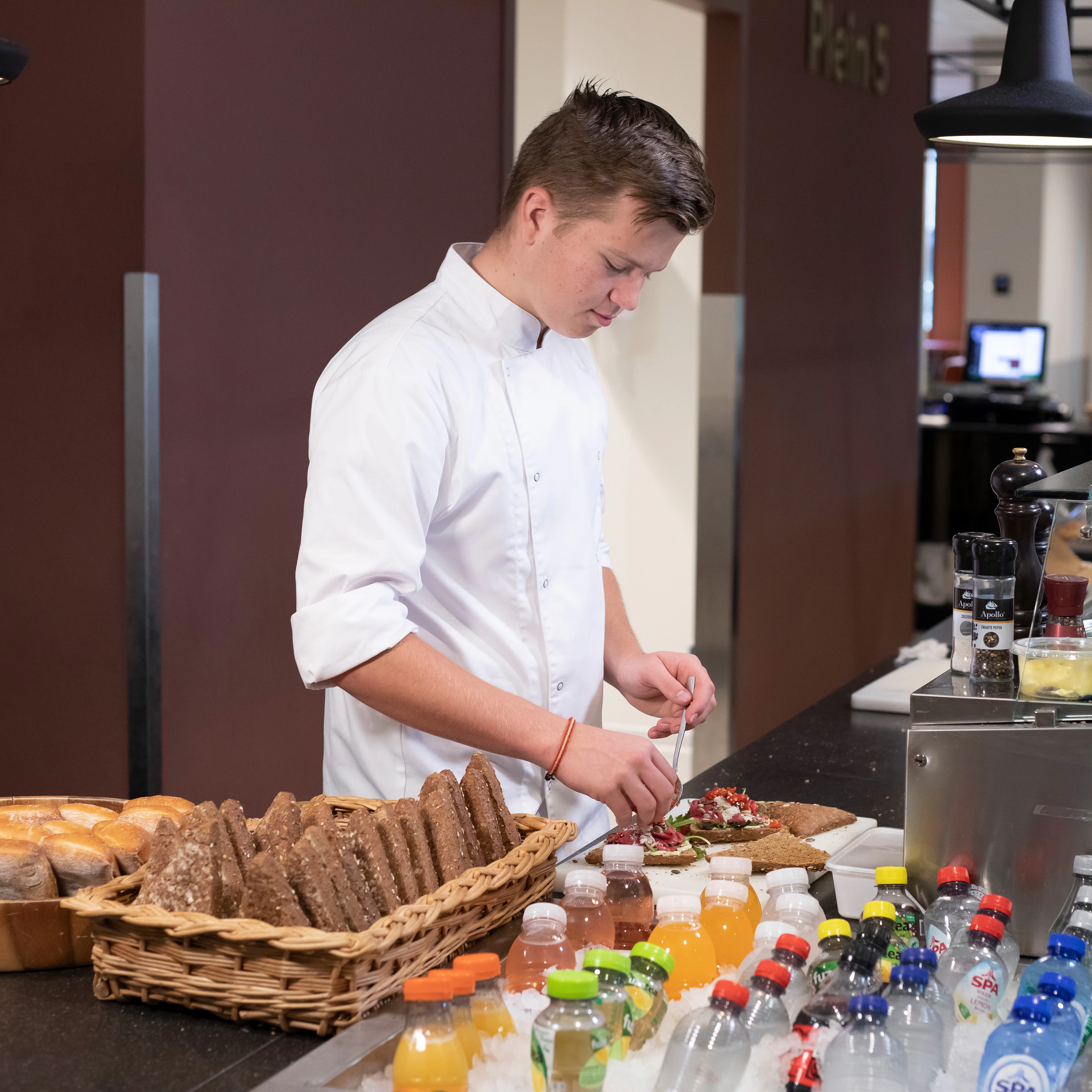 Jongen is bezig met het klaarmaken van luxe broodjes