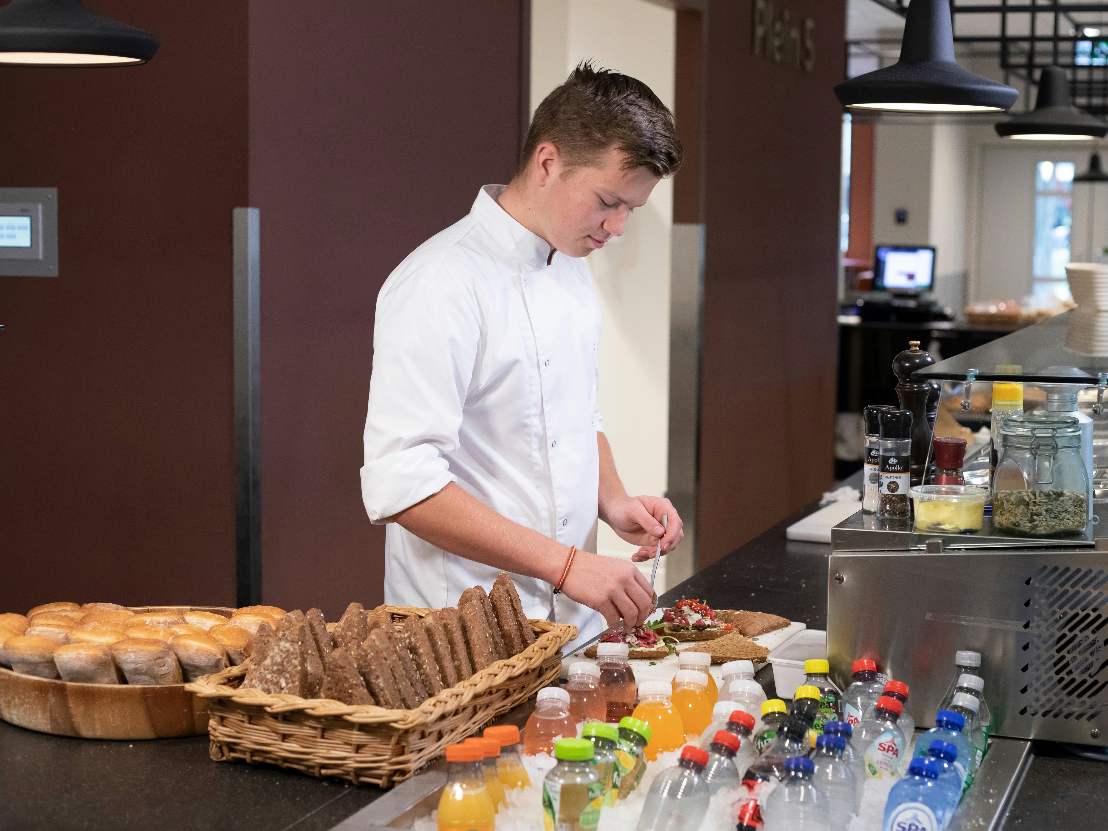 Jongen is bezig met het klaarmaken van luxe broodjes