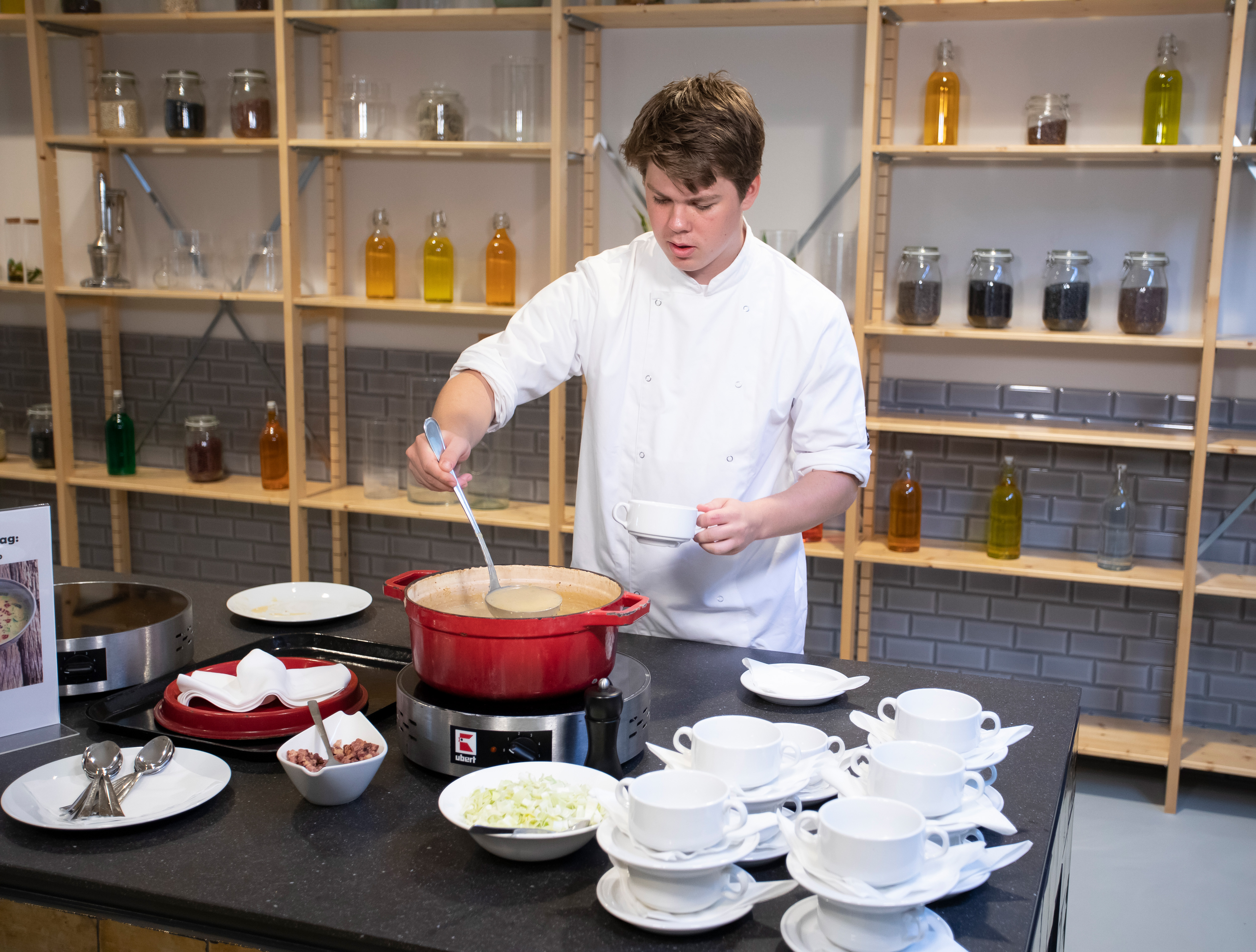 Jongen schept een kom soep in