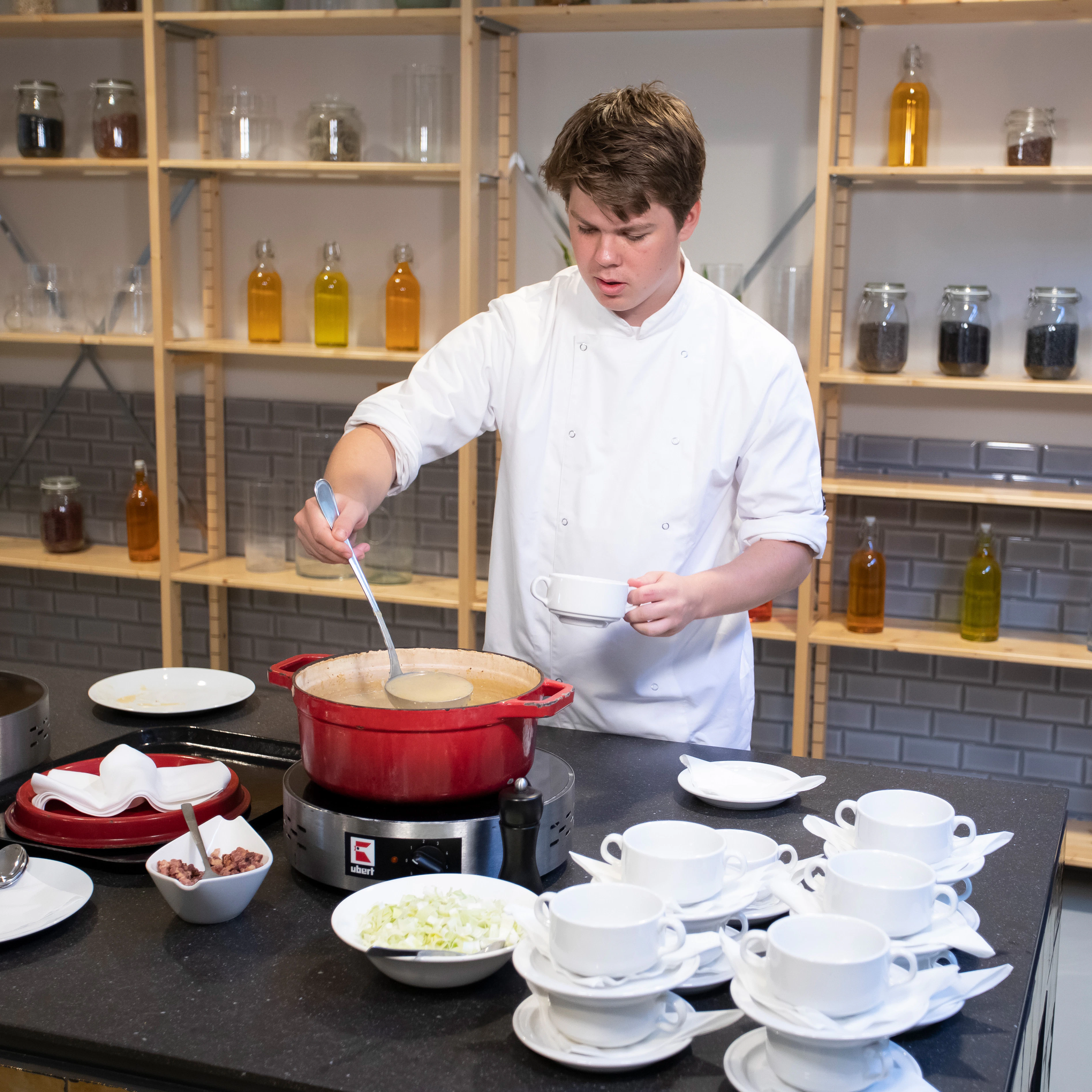 Jongen schept een kom soep in