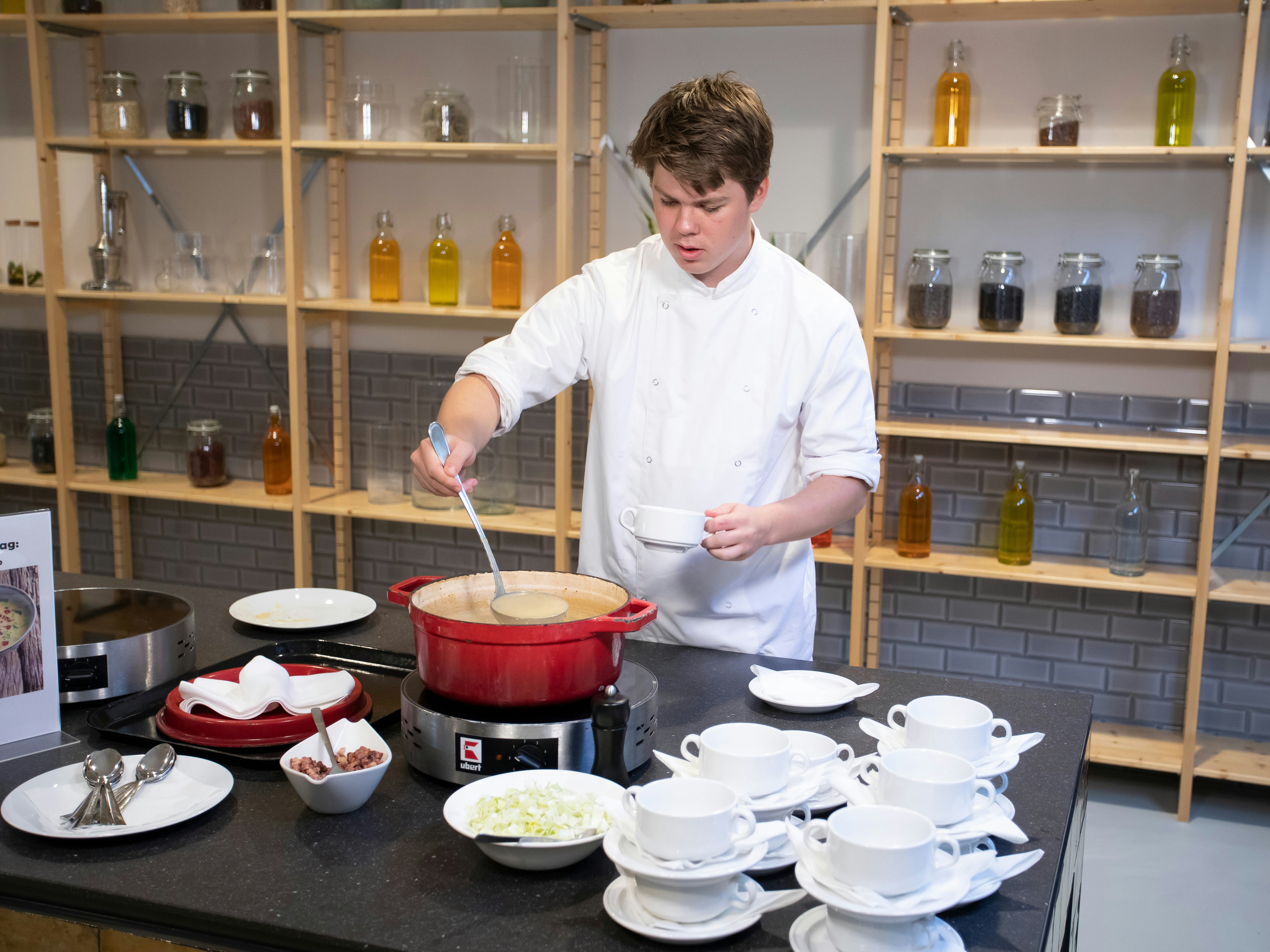 Jongen schept een kom soep in