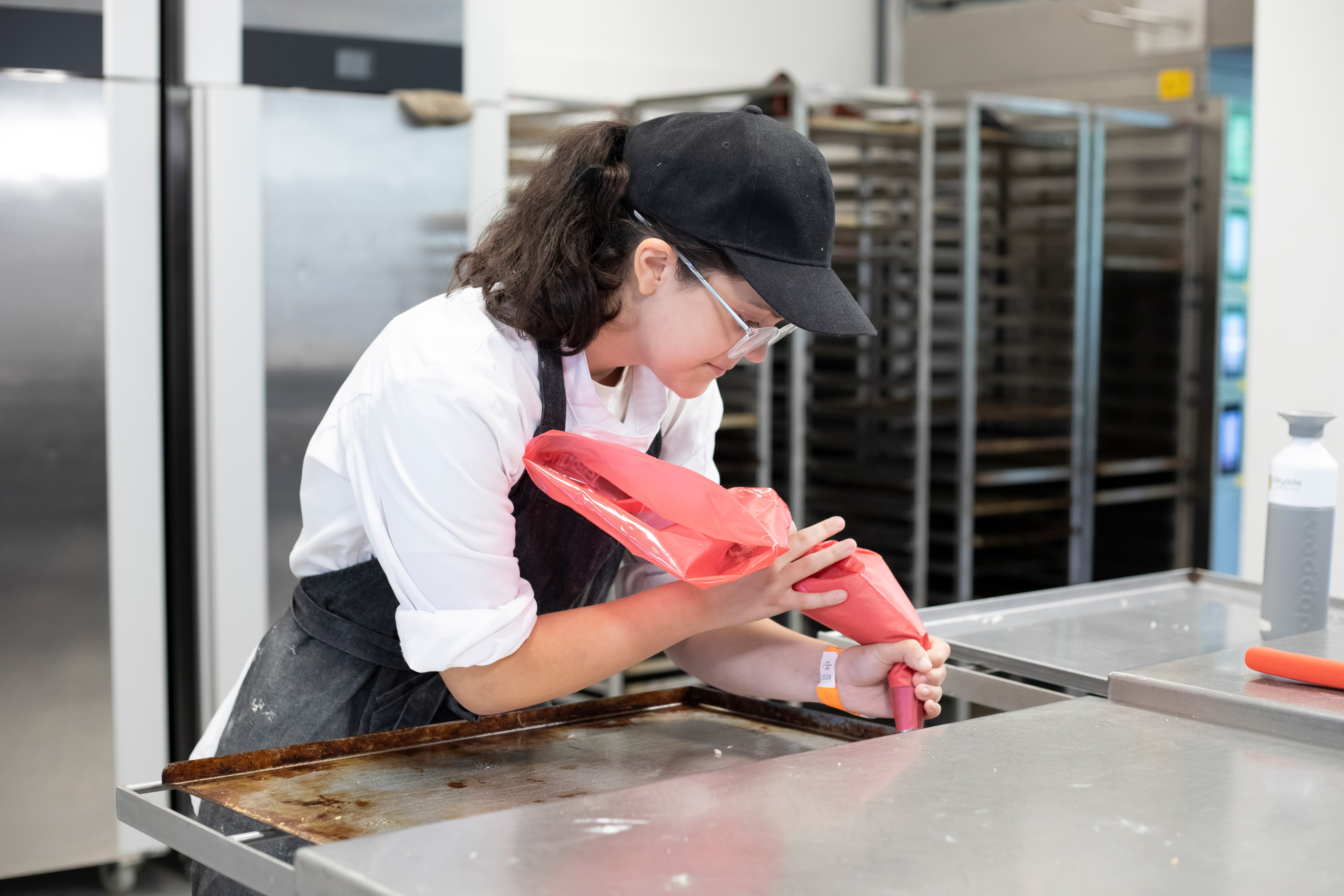 Student is bezig met een spuitzak met beslag erin