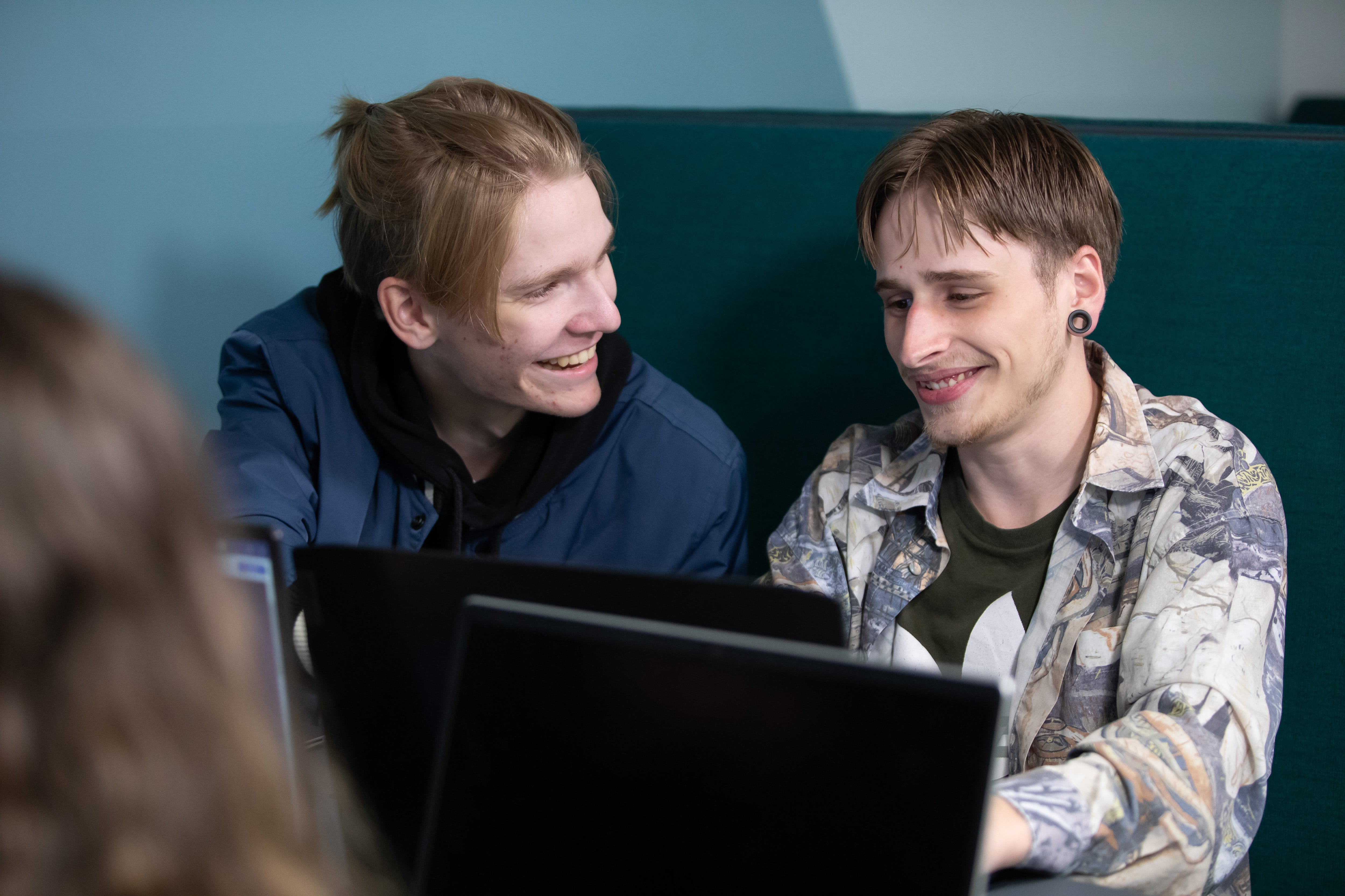 Studenten lachen samen met laptop