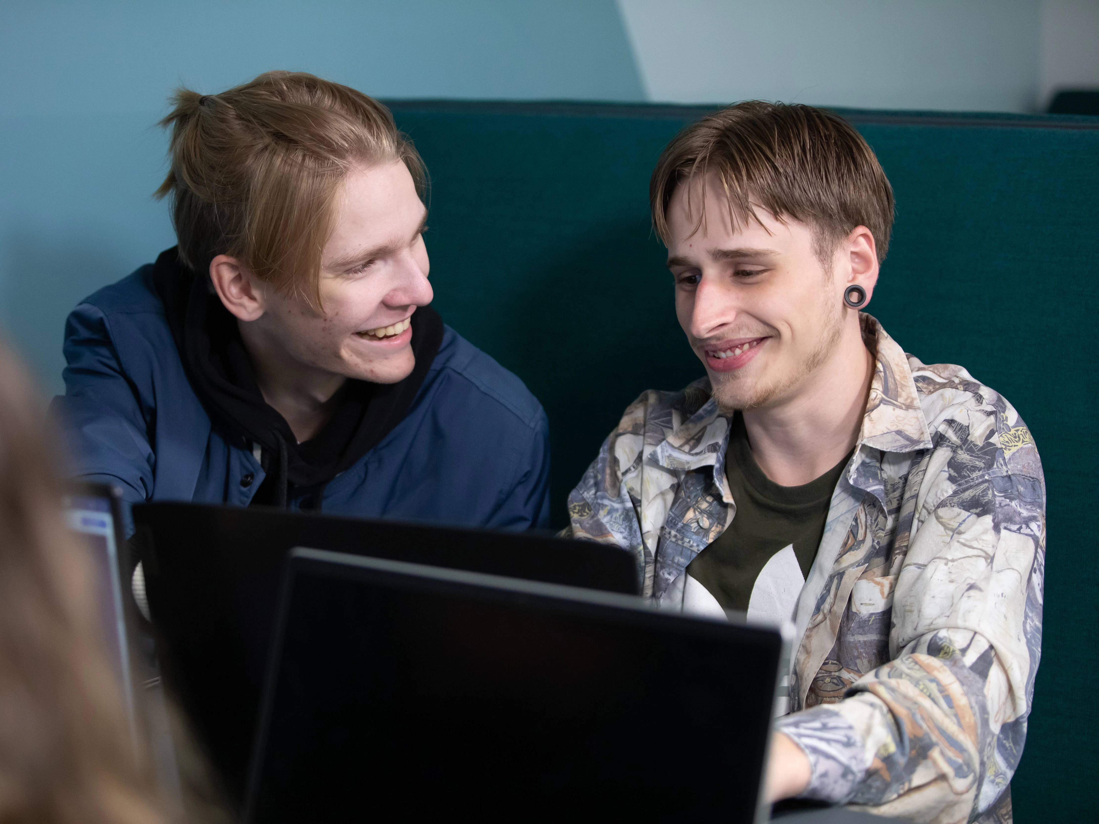 Studenten lachen samen met laptop