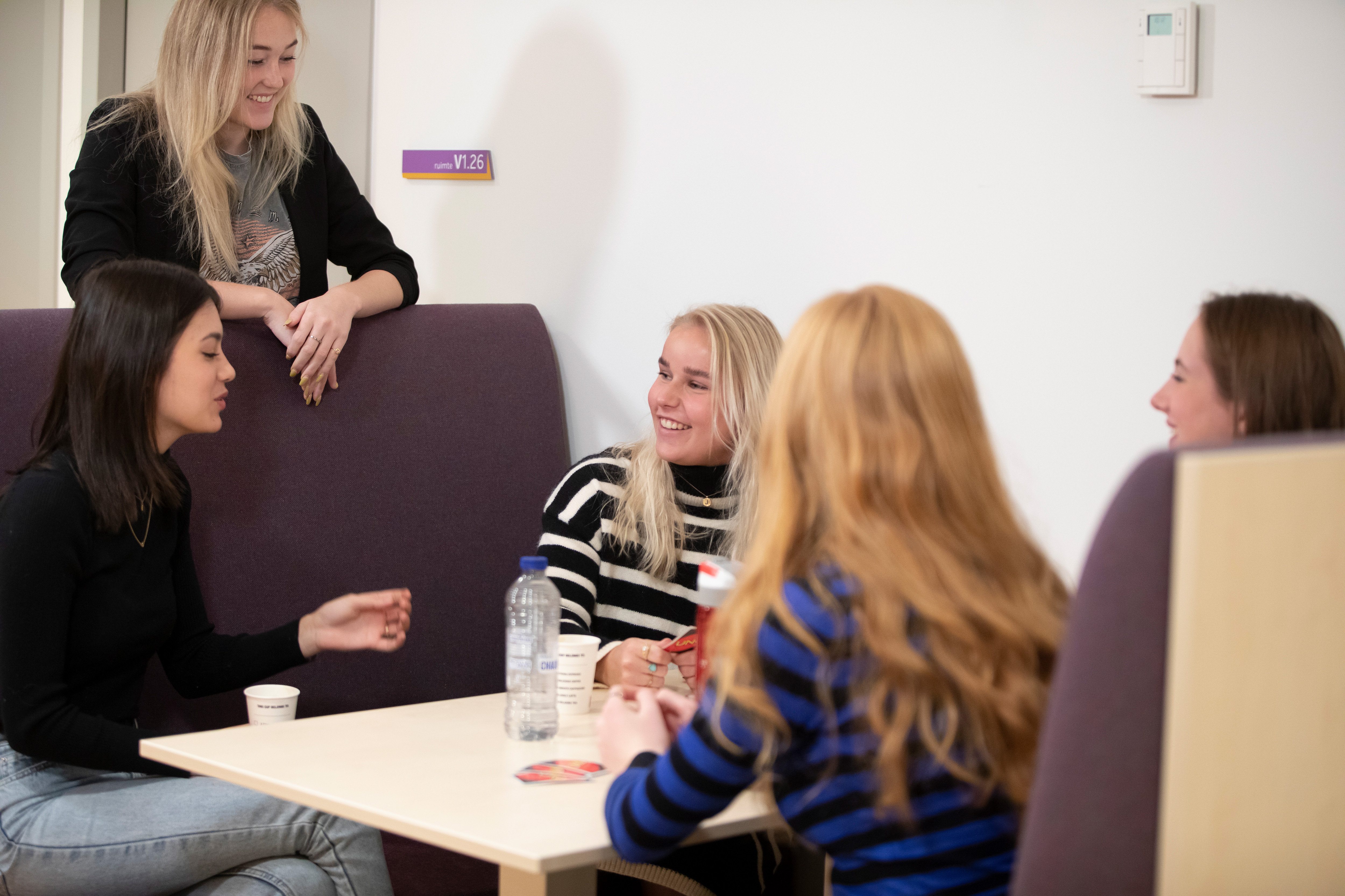 Studenten zijn met elkaar aan het praten terwijl ze aan tafel zitten