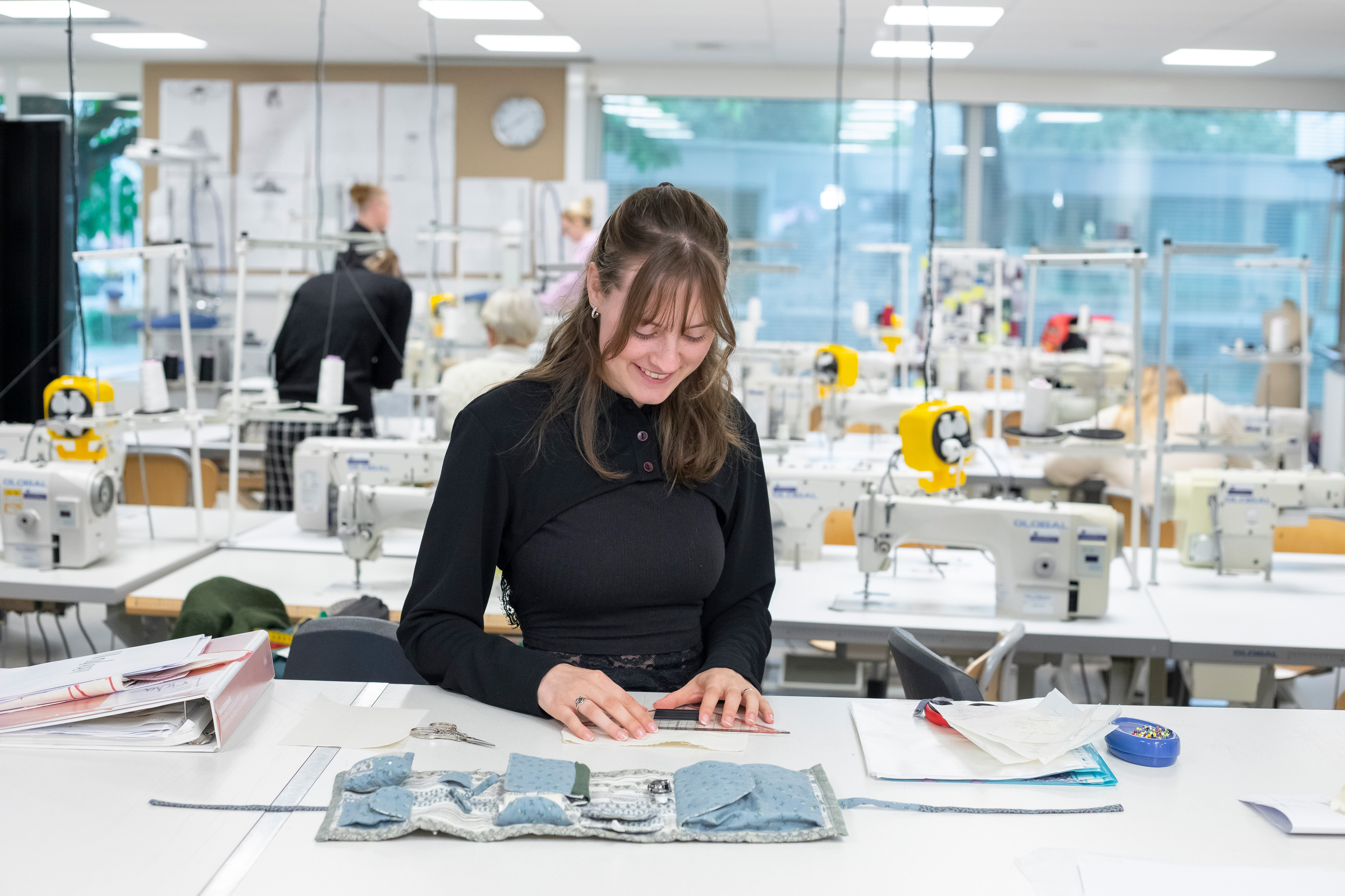 Student is bezig met het uitzoeken van stof voor kleding