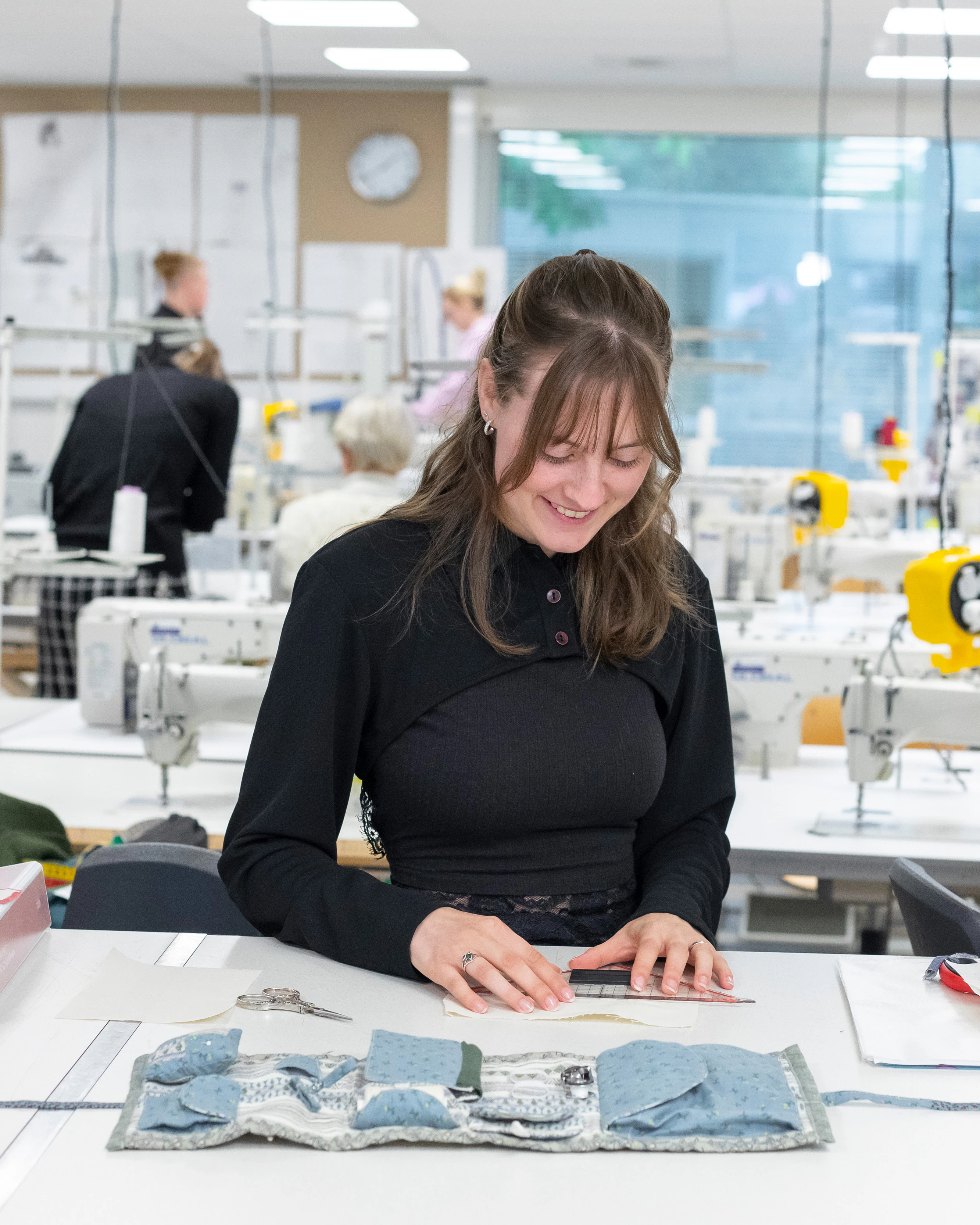 Student is bezig met het uitzoeken van stof voor kleding