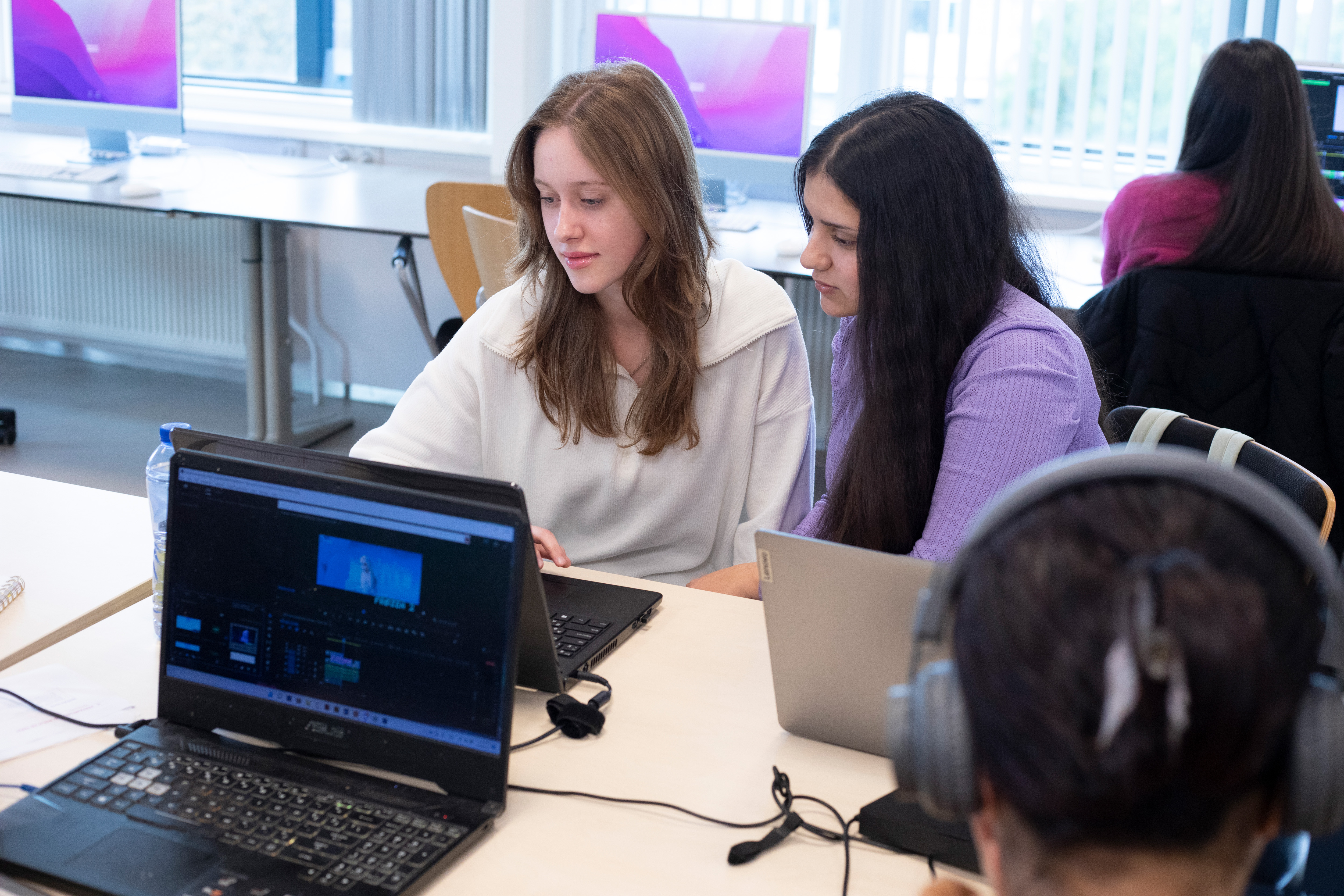 Twee studenten kijken naar een laptopscherm