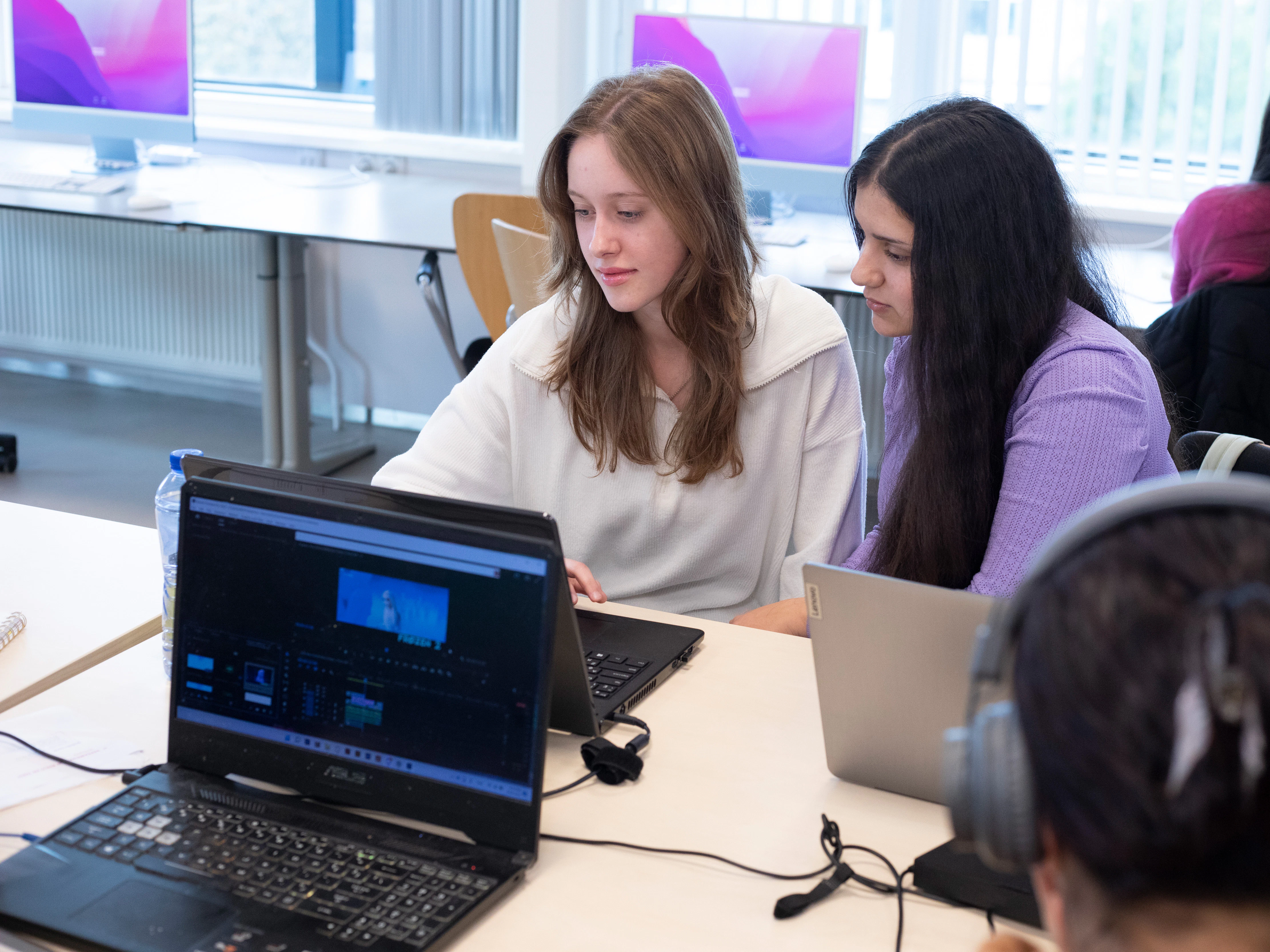 Twee studenten kijken naar een laptopscherm
