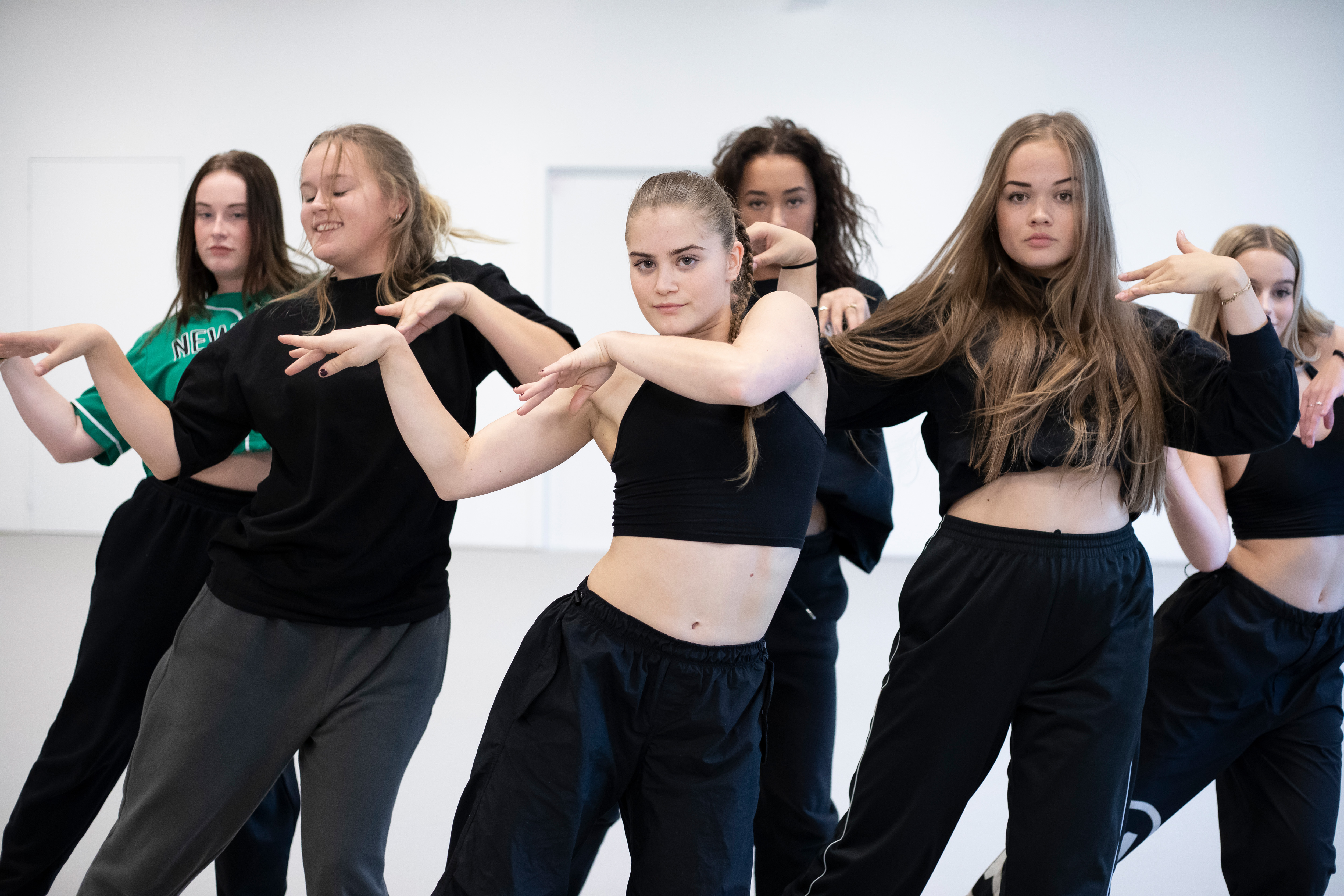 Studenten poseren voor de camera in een danspose in een danslokaal