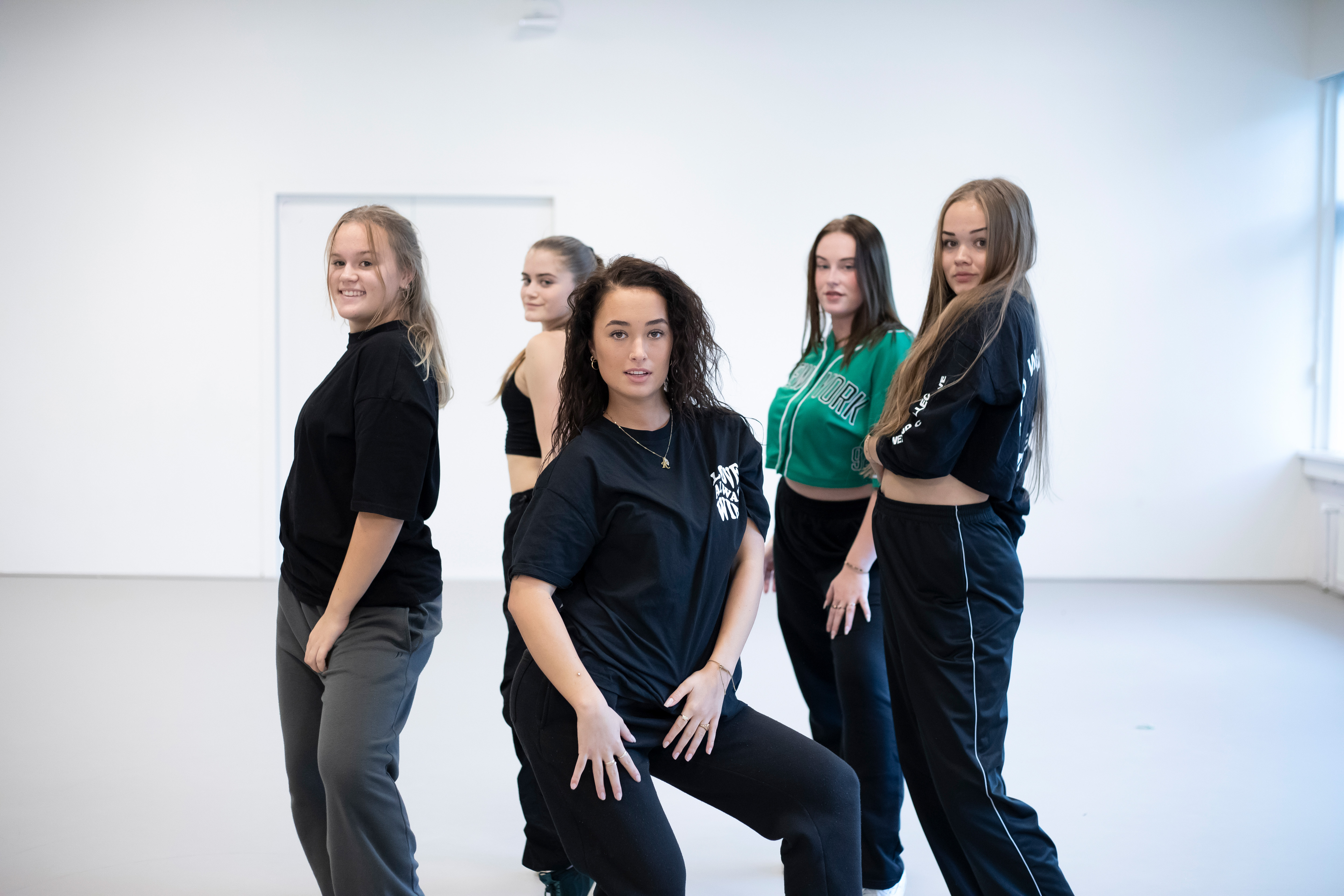 Studenten poseren voor de camera in een danspose in een danslokaal