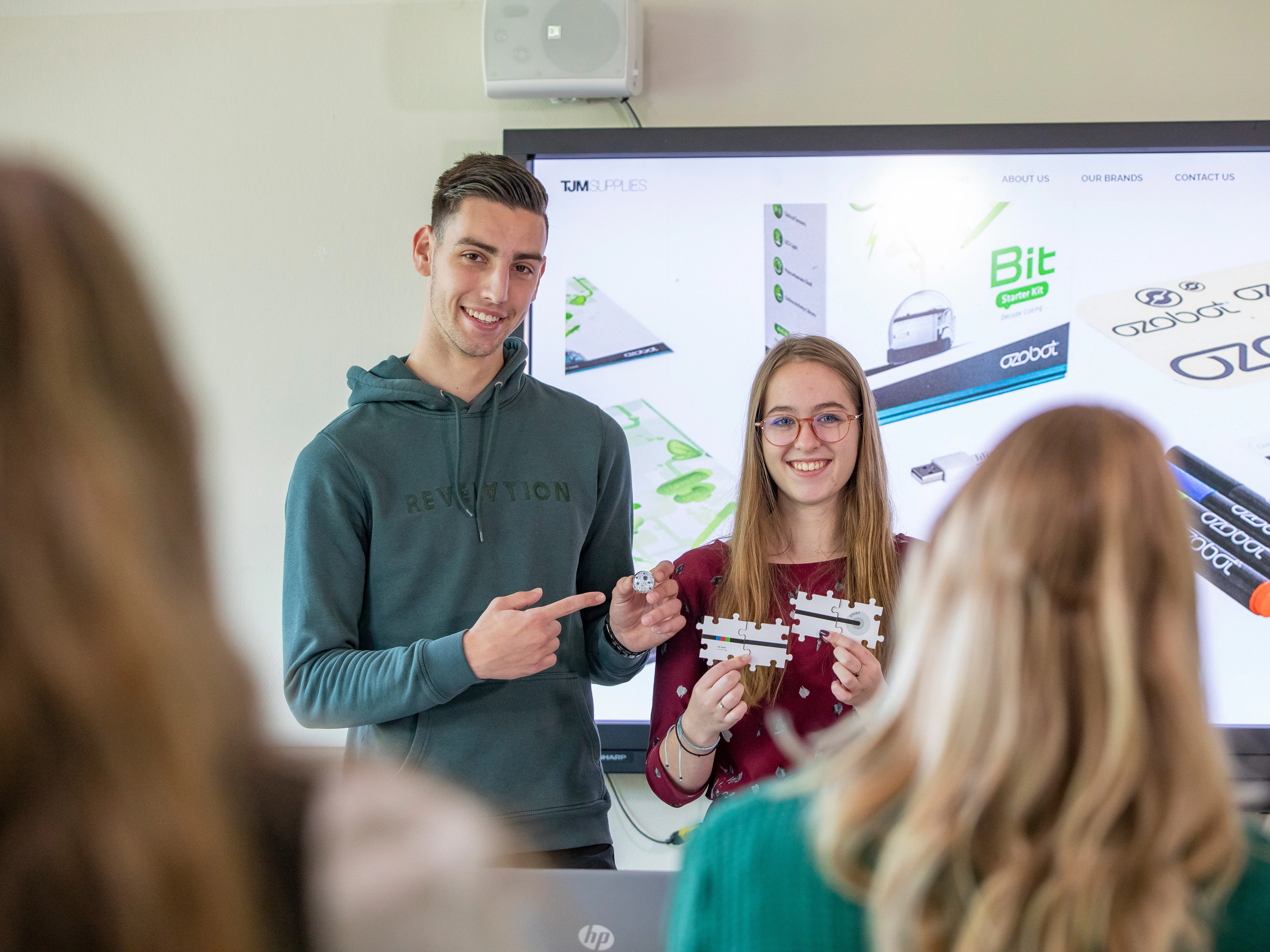 Twee studenten staan voor de klas