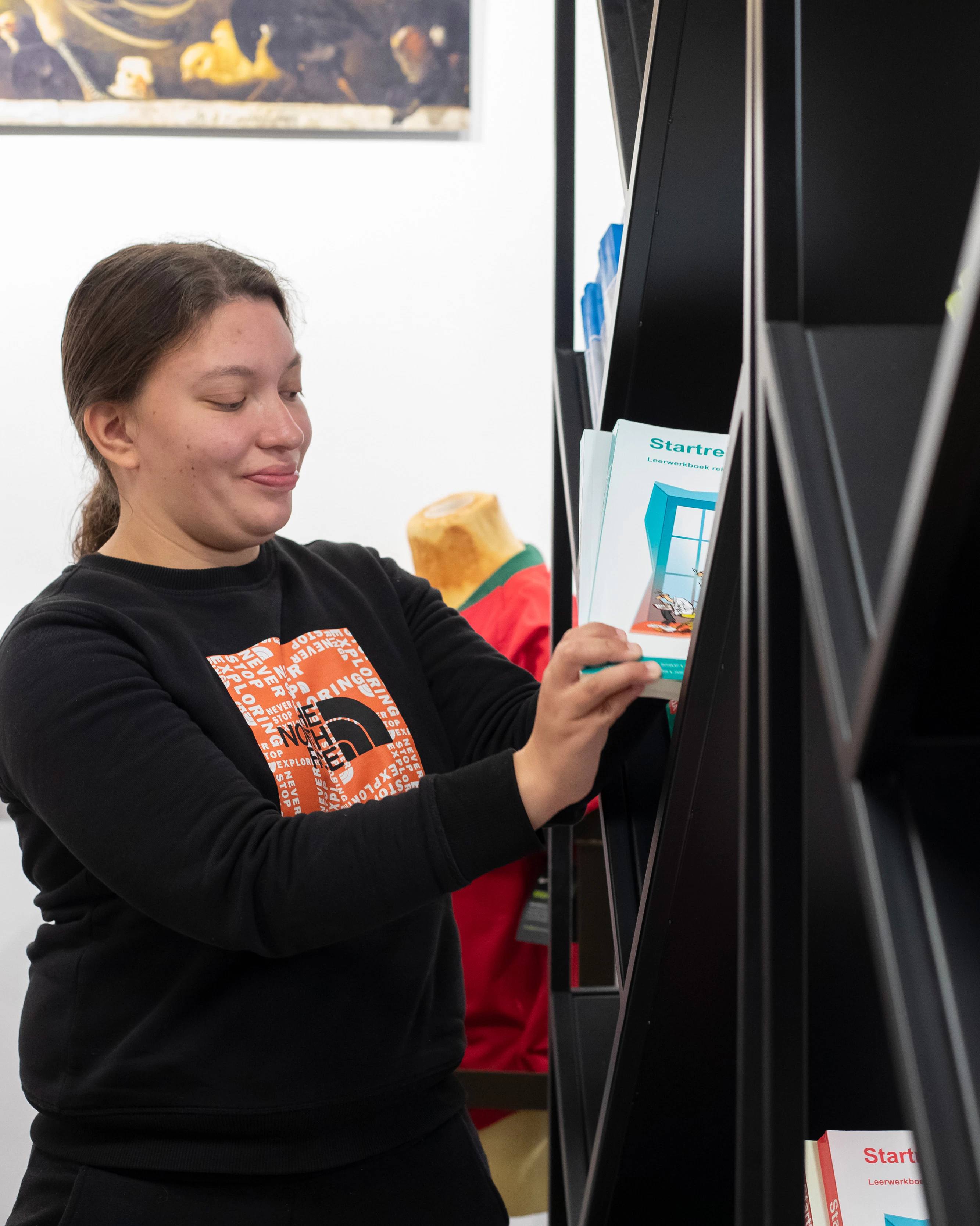 Student zet boeken in kast