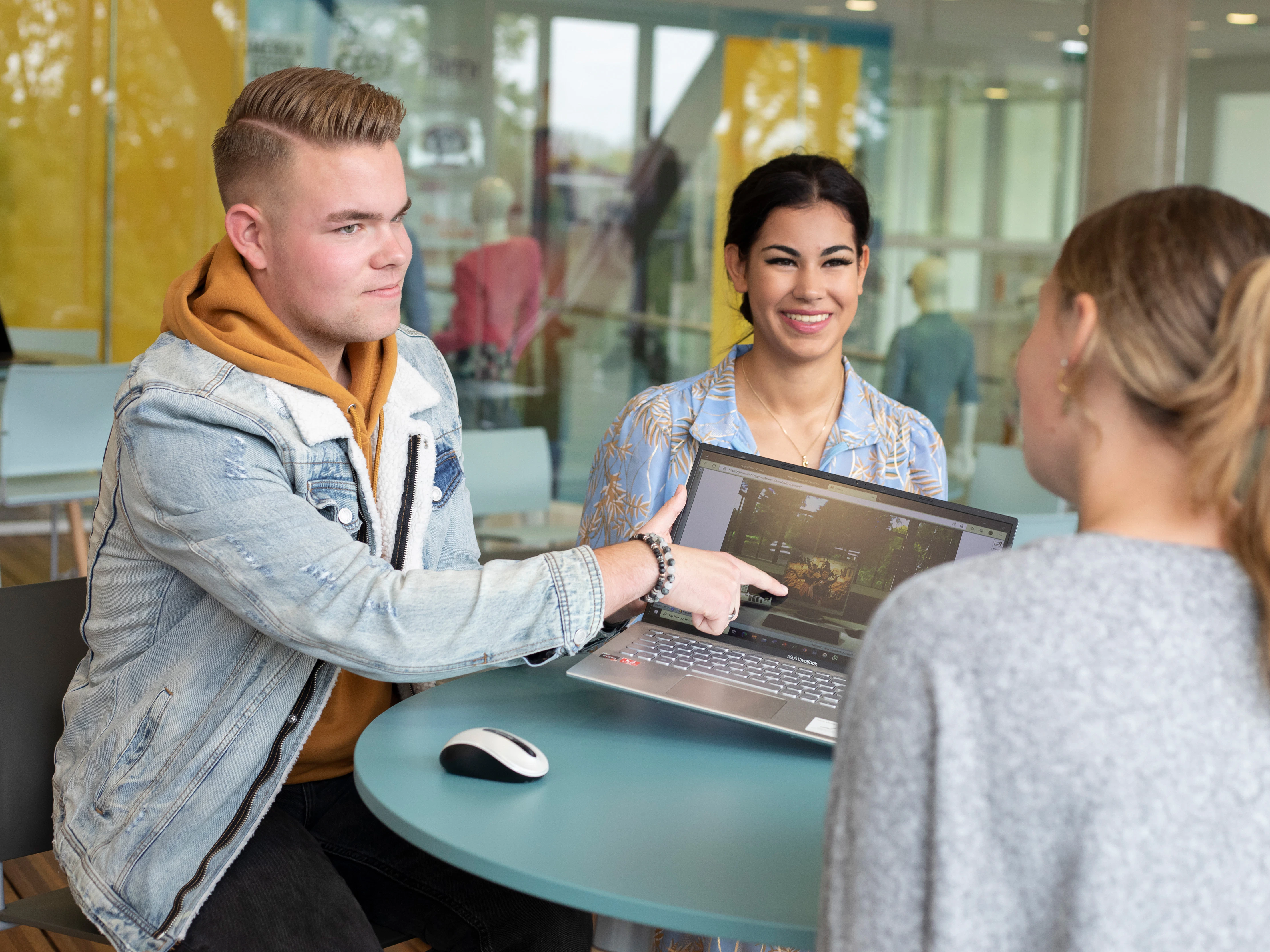 Drie studenten overleggen met elkaar
