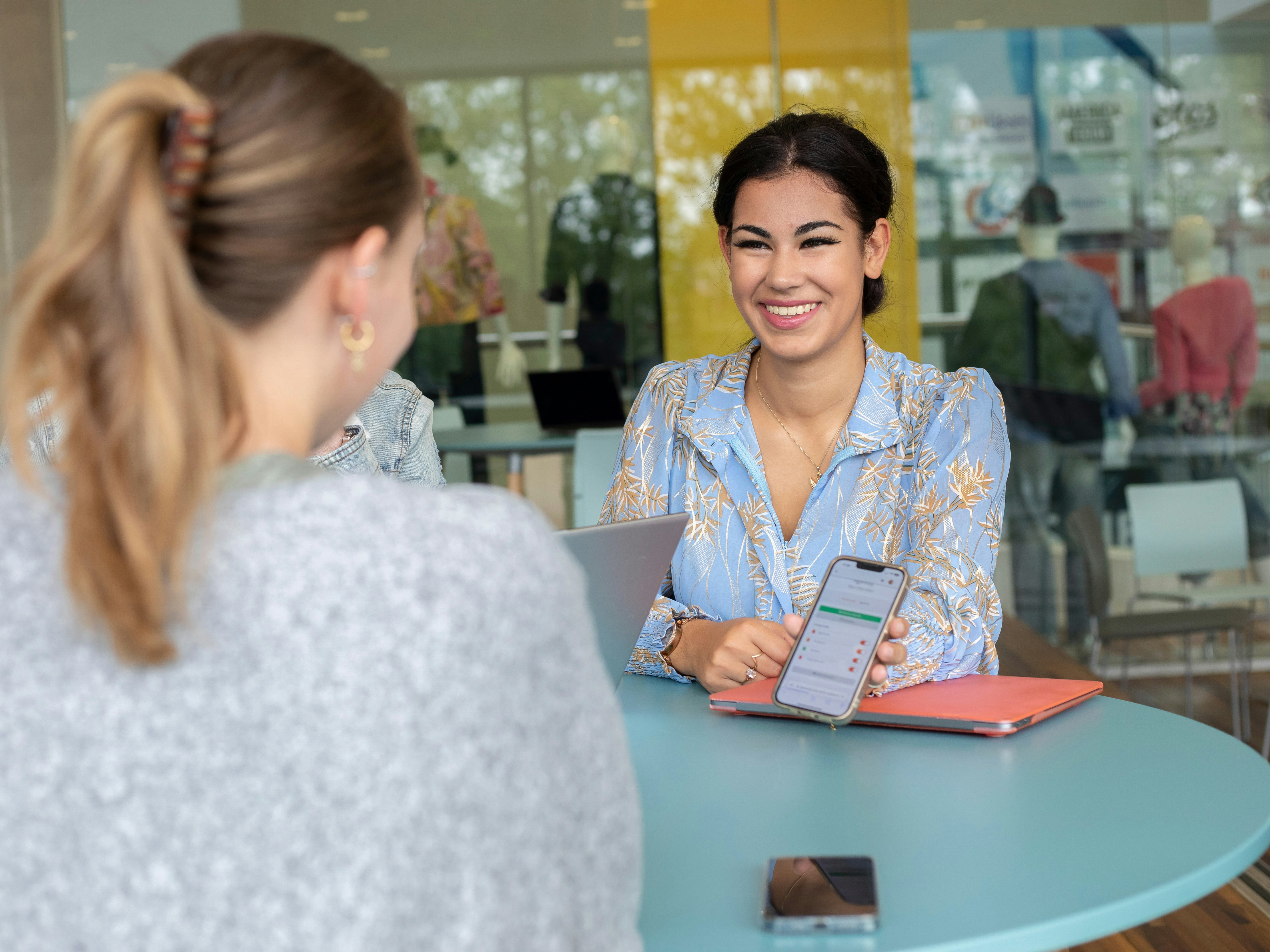 Studenten overleggen met elkaar aan hoge tafel