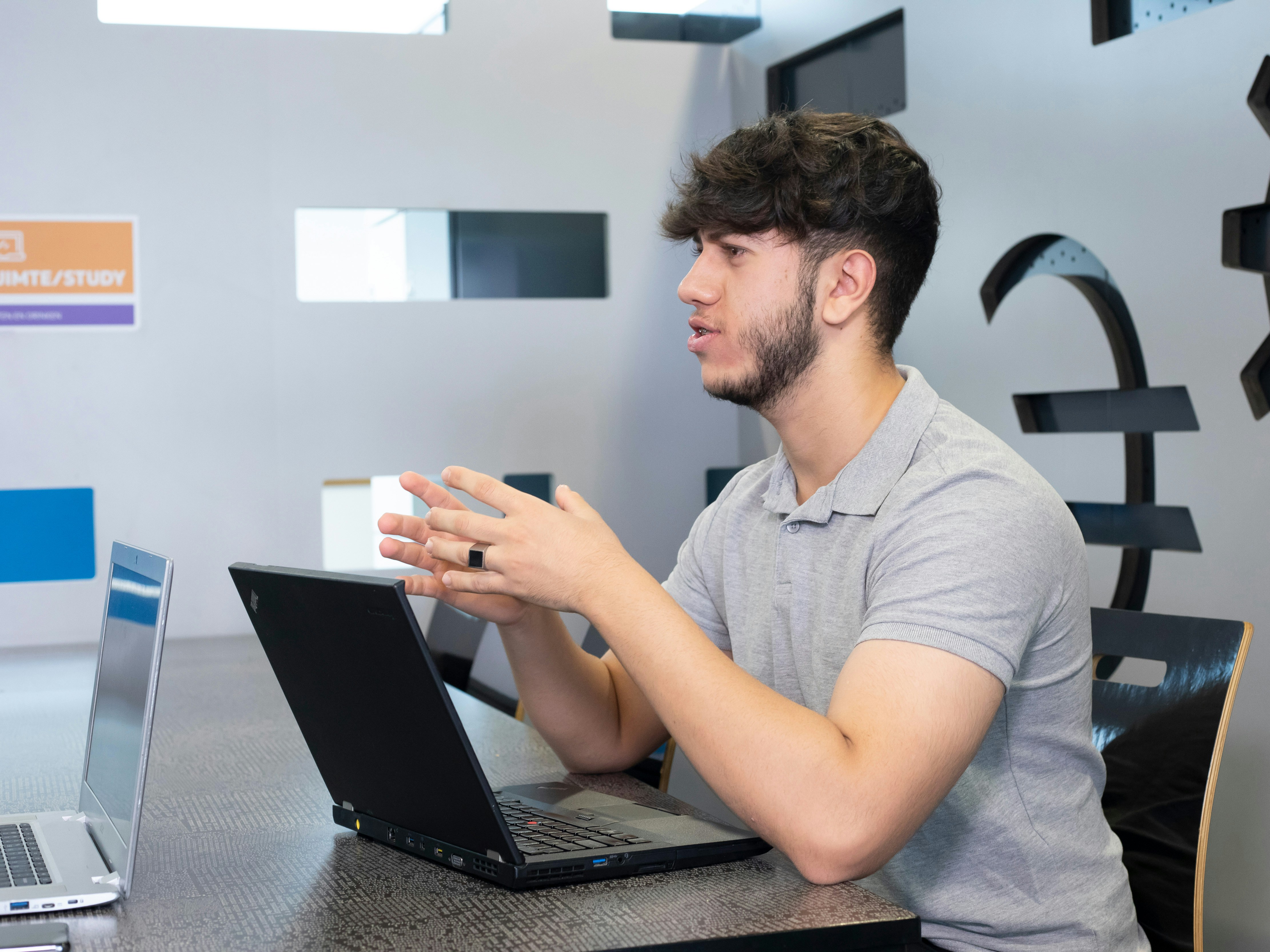 Een jongen pratend achter een laptop