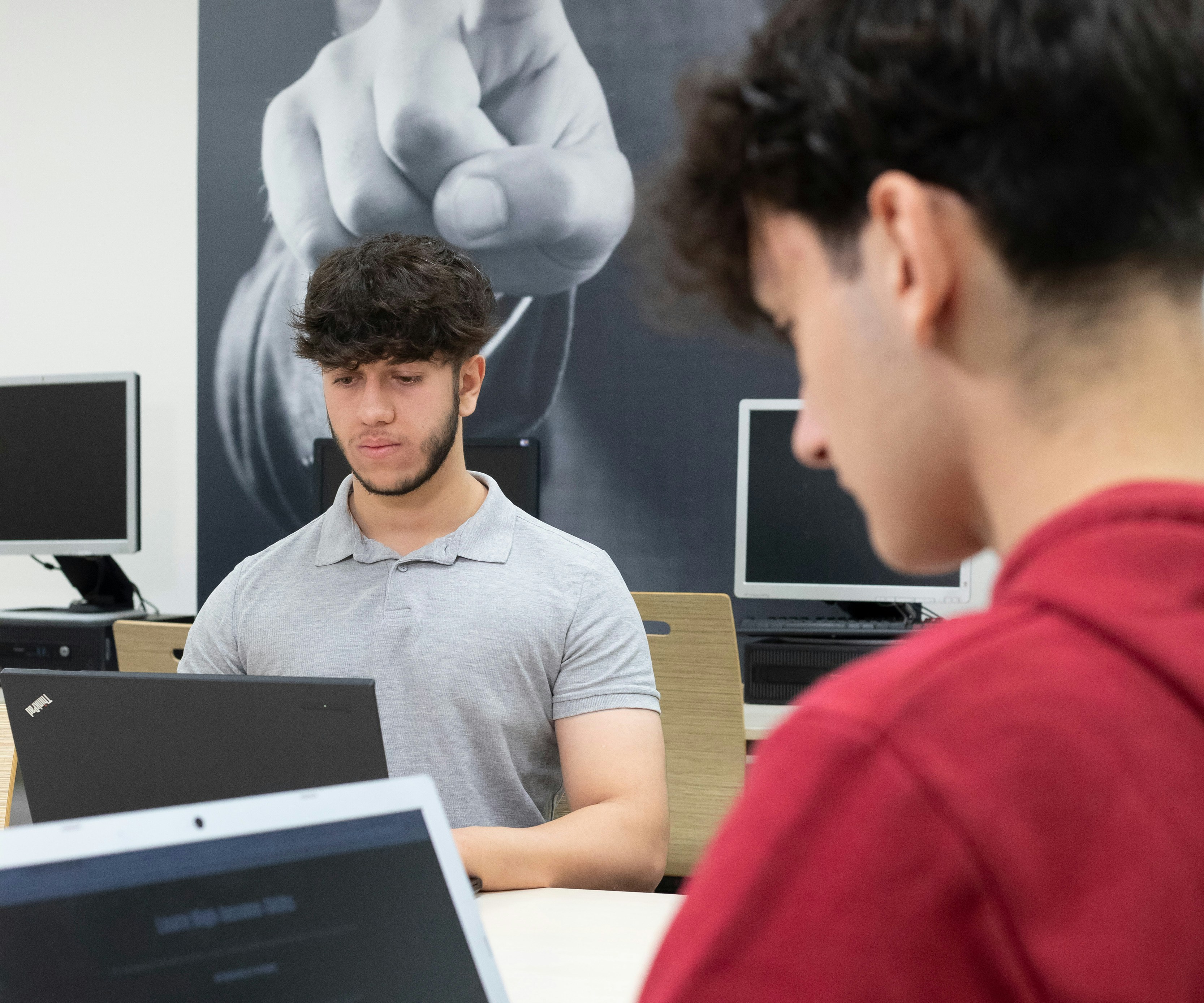 Een jongen werkend achter een laptop