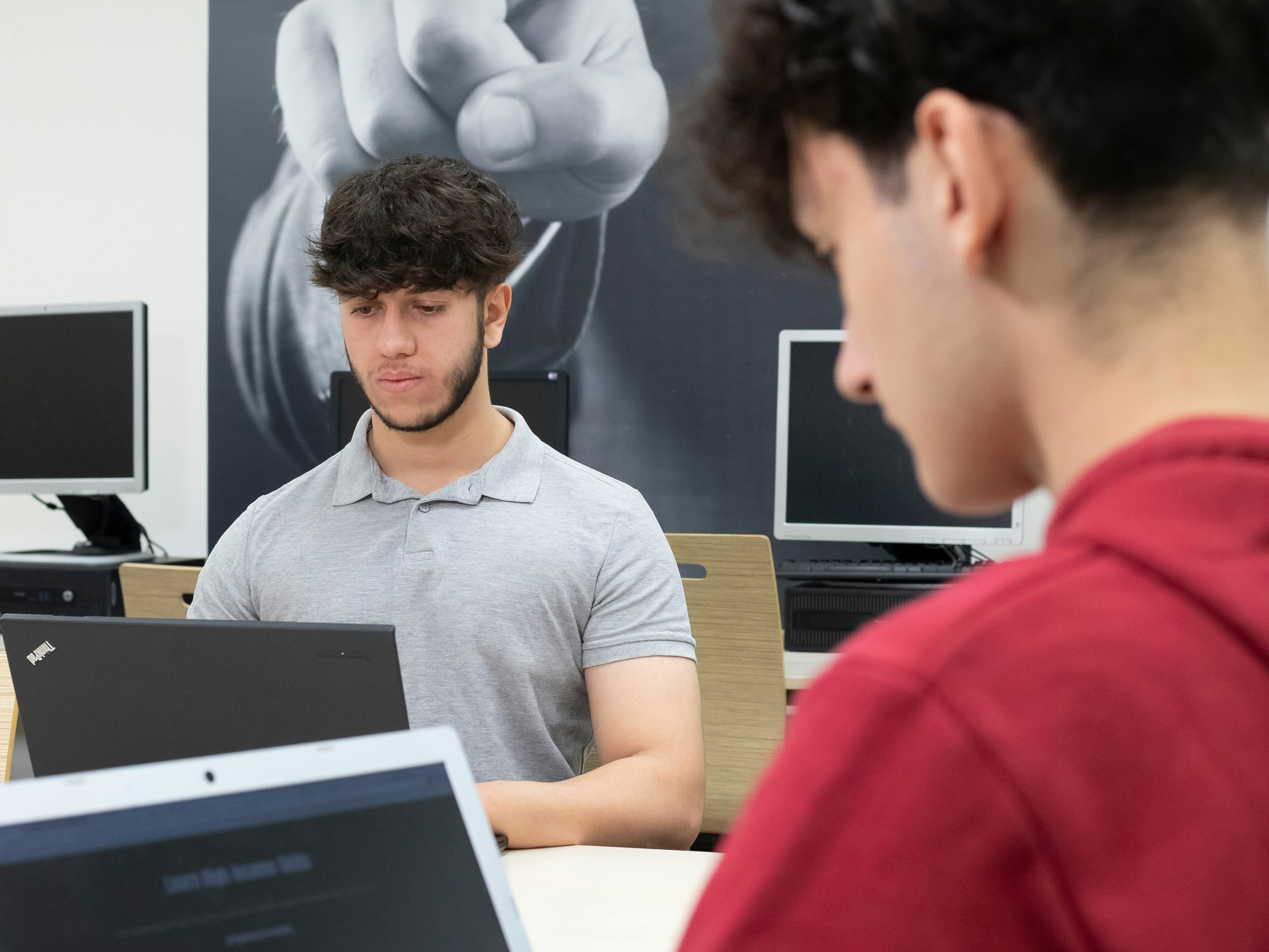 Een jongen werkend achter een laptop