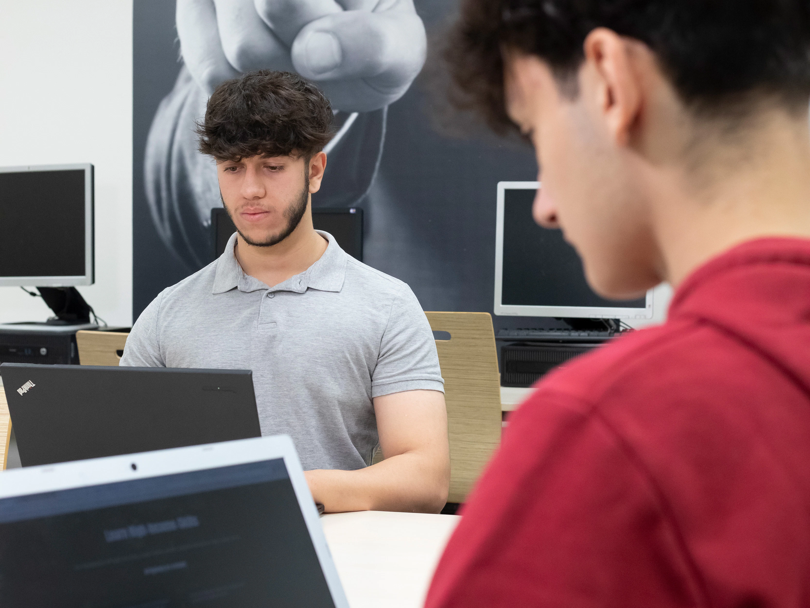 twee jongens aan het werk achter een laptop