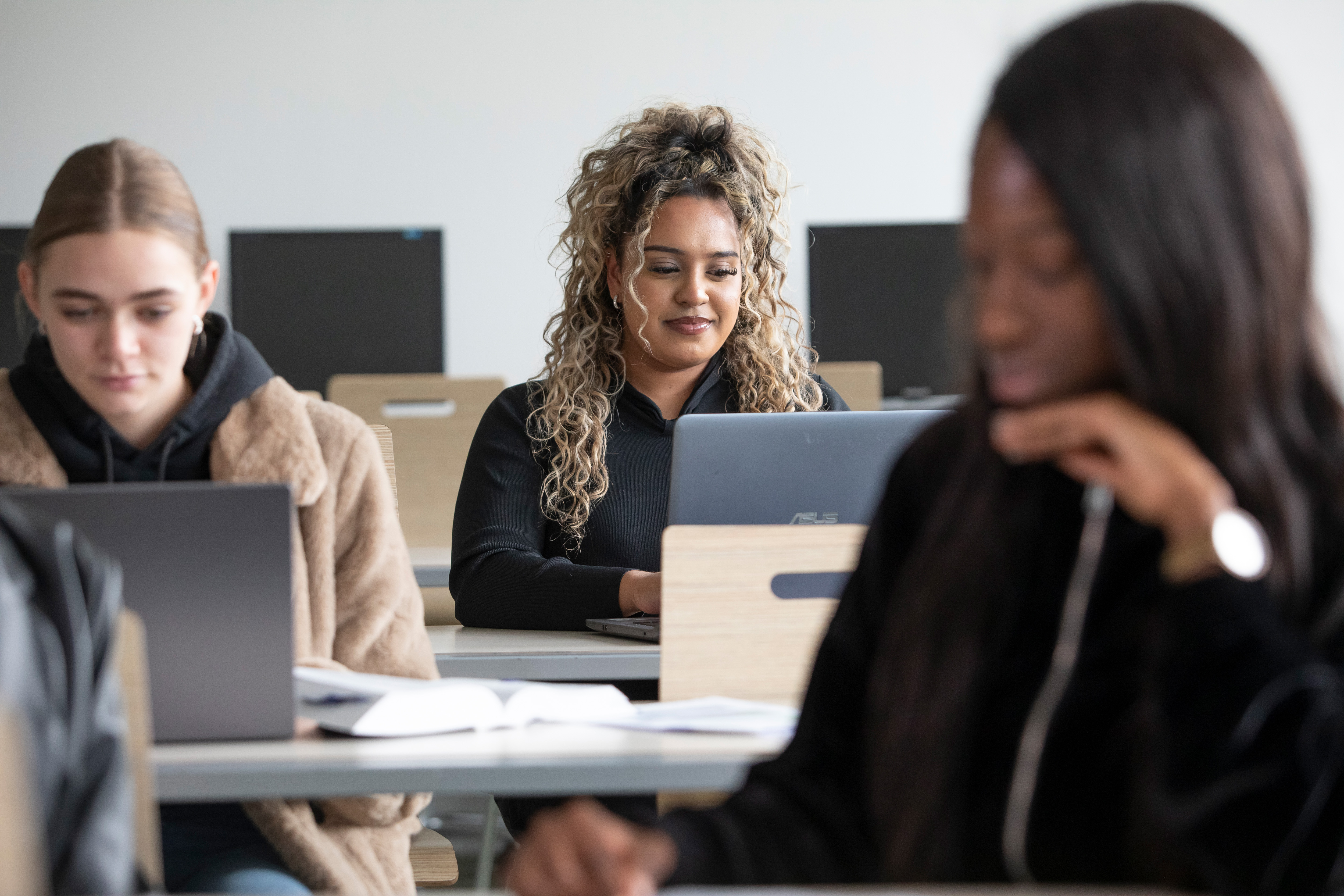 2 studenten zitten achter een laptop achter een bureau
