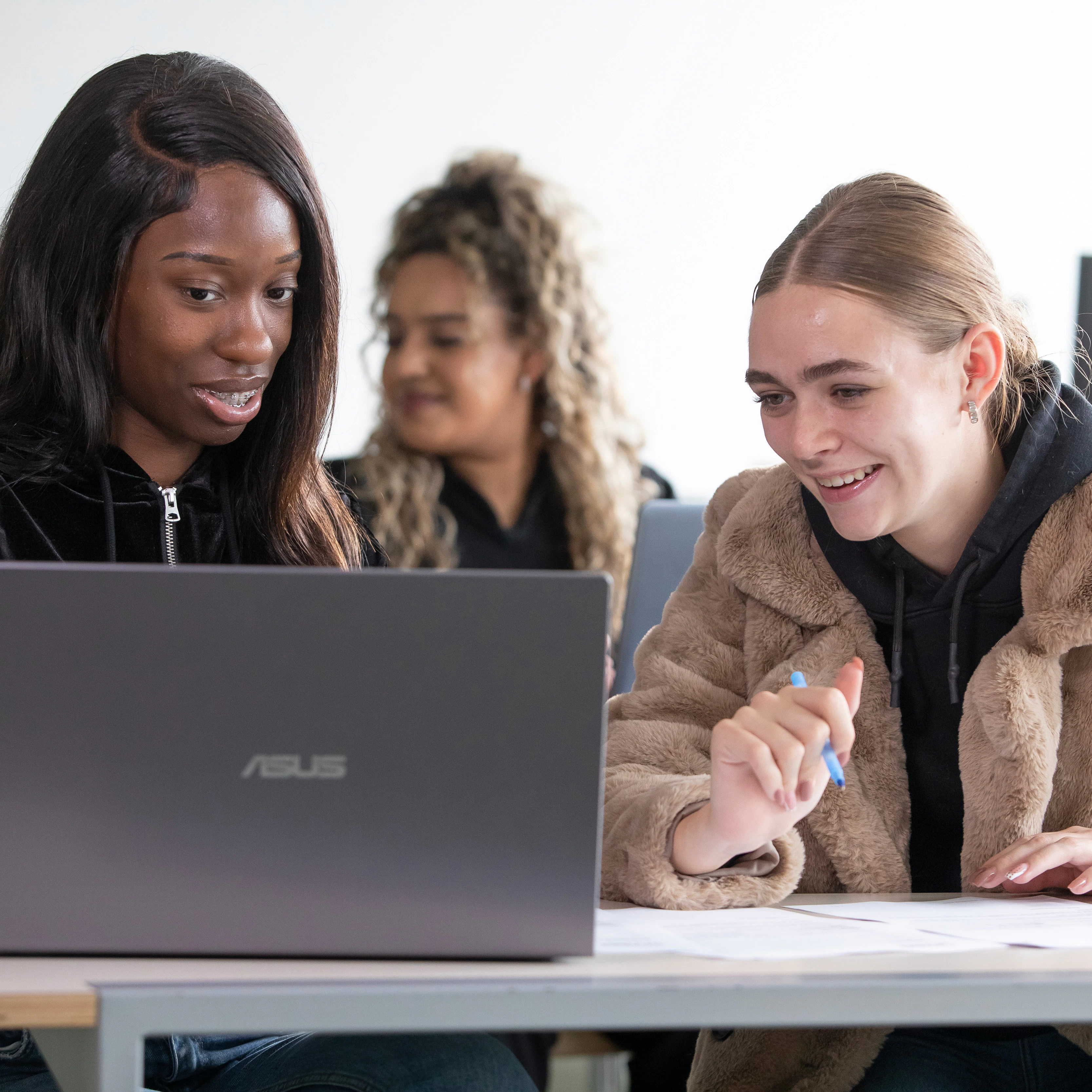 Twee studenten overleggen achter laptop