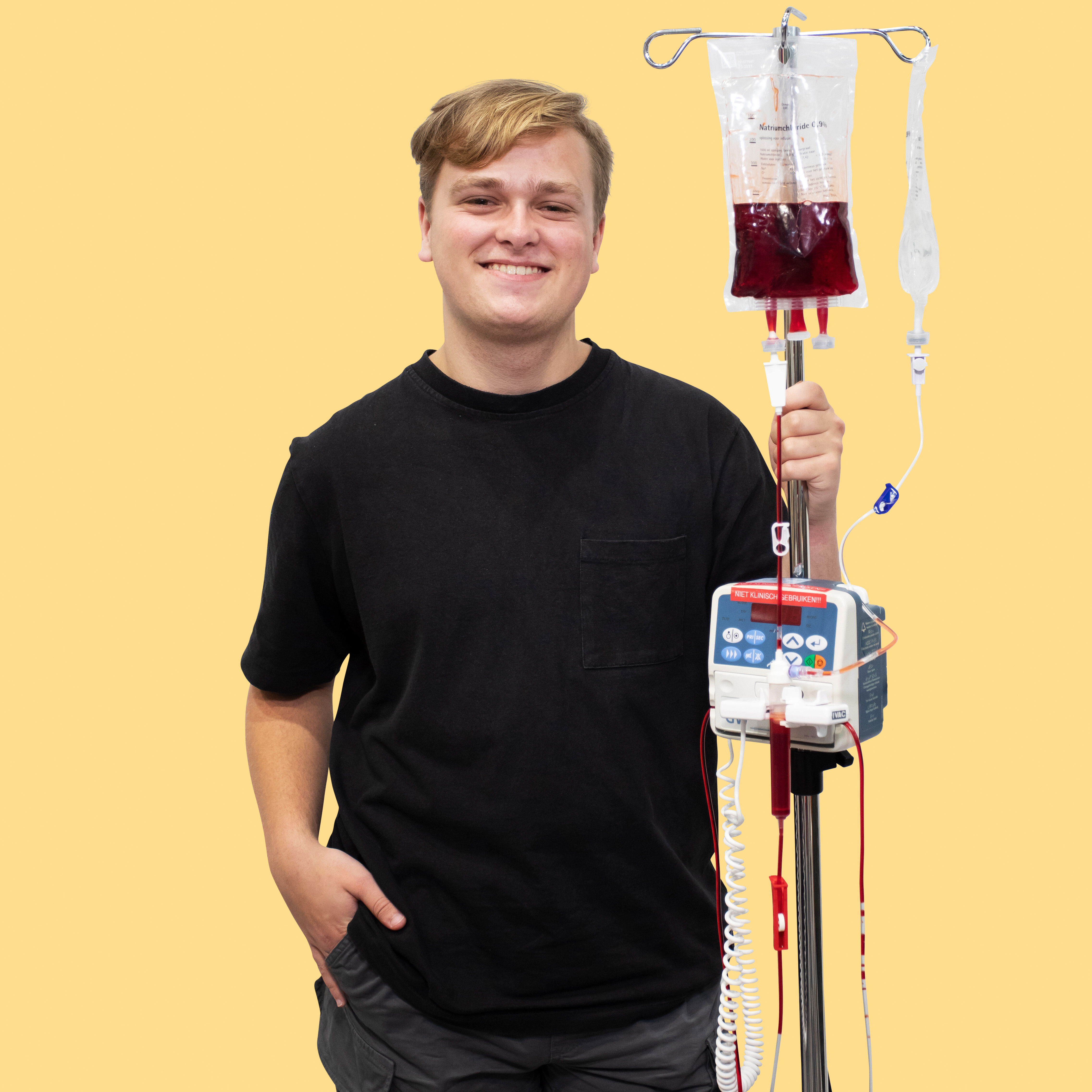 Jongen met een zwart shirt aan houdt een stethoscoop en een infuusstrandaard vast