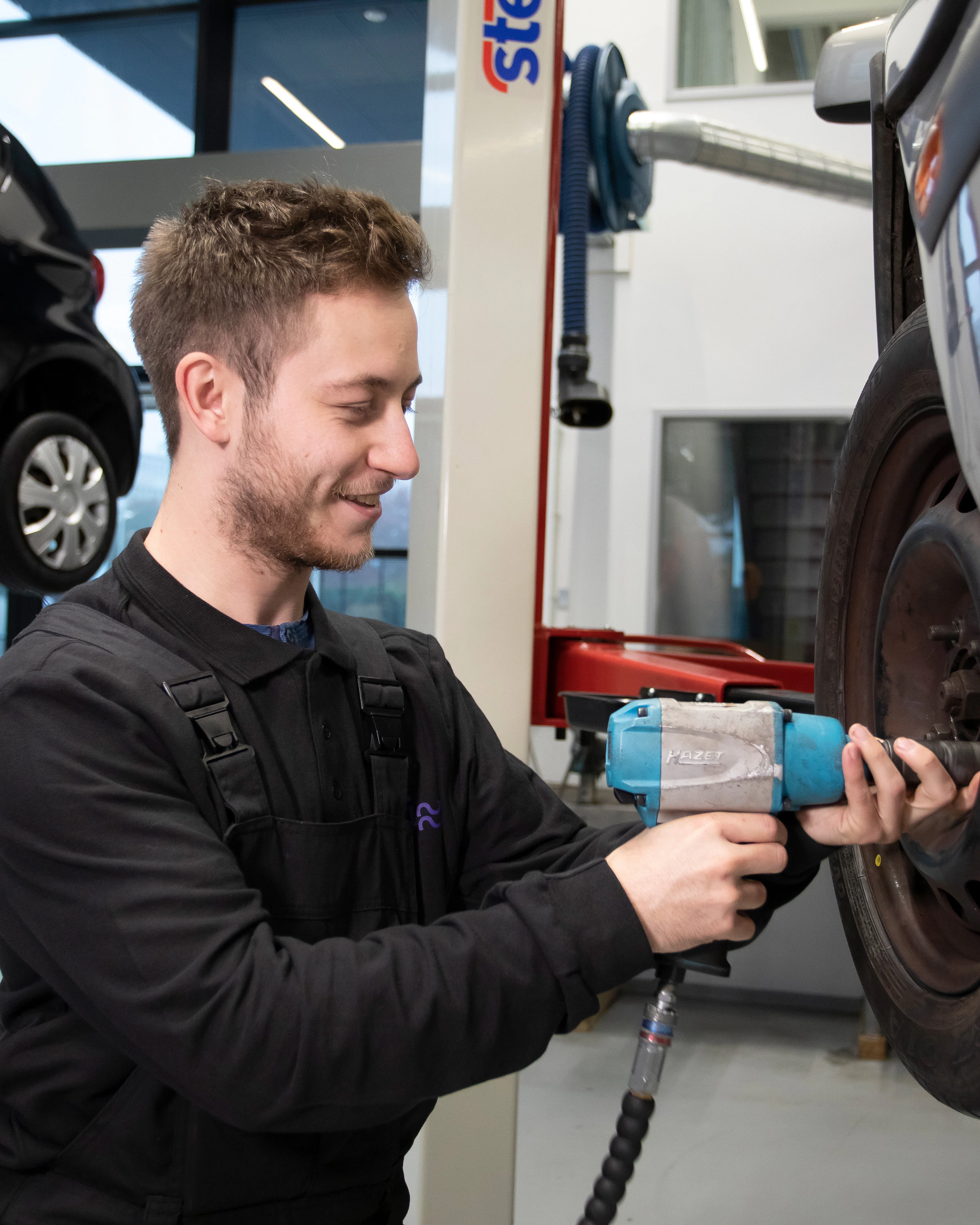 Student is bezig met een wiel van een auto los te maken