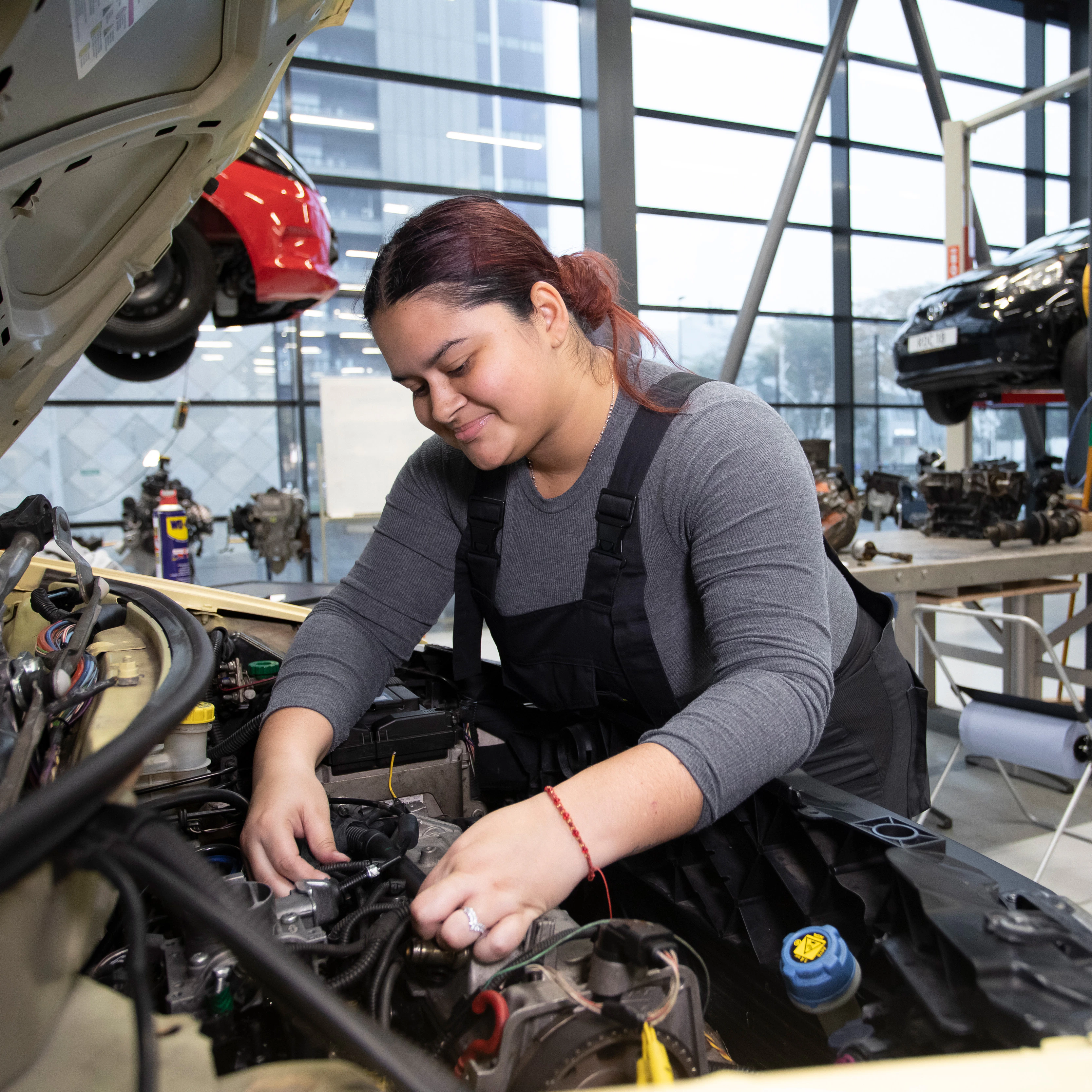 Student is bezig onder de motorkap van de auto