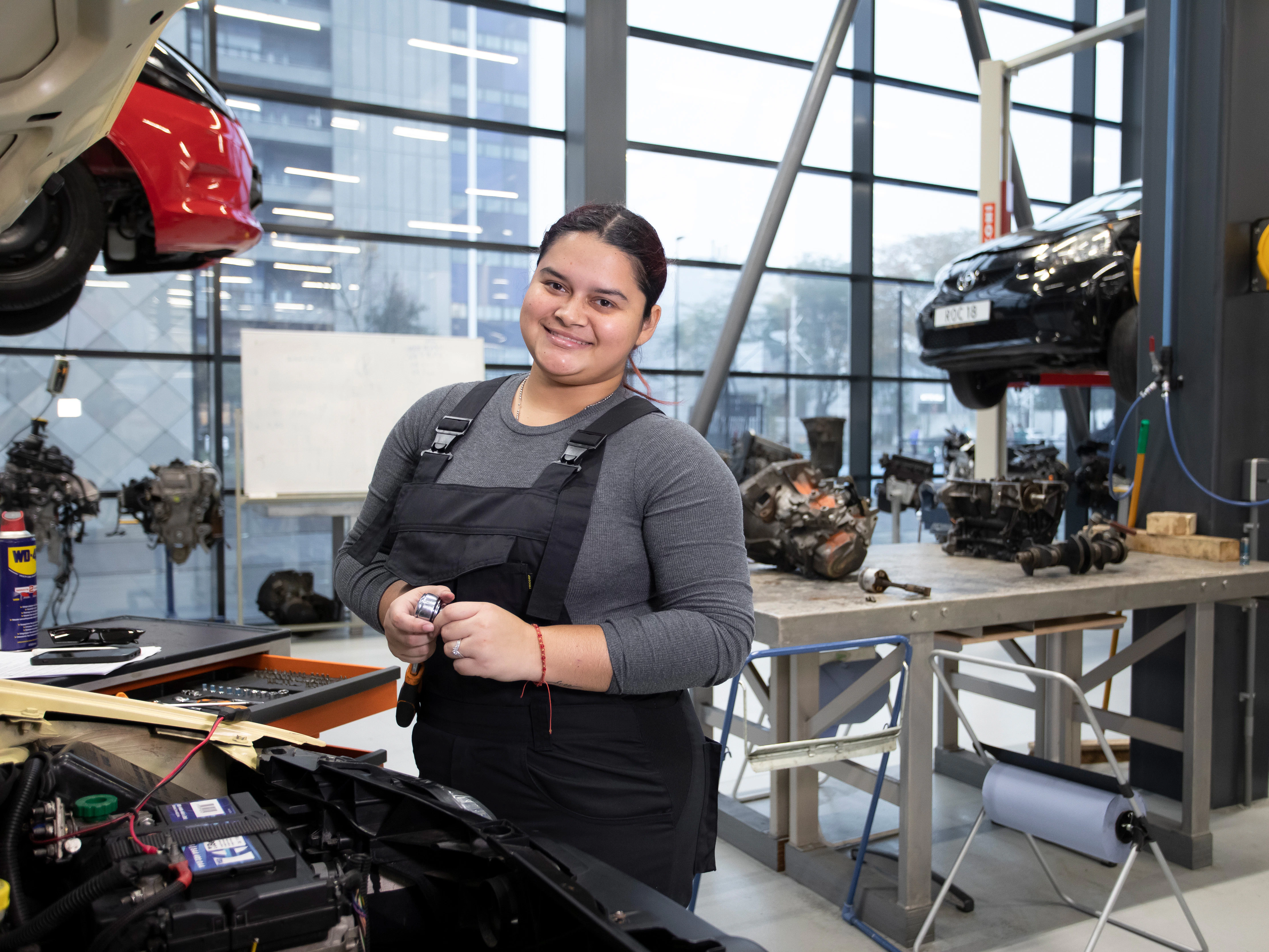 Student is bezig onder de motorkap van een auto