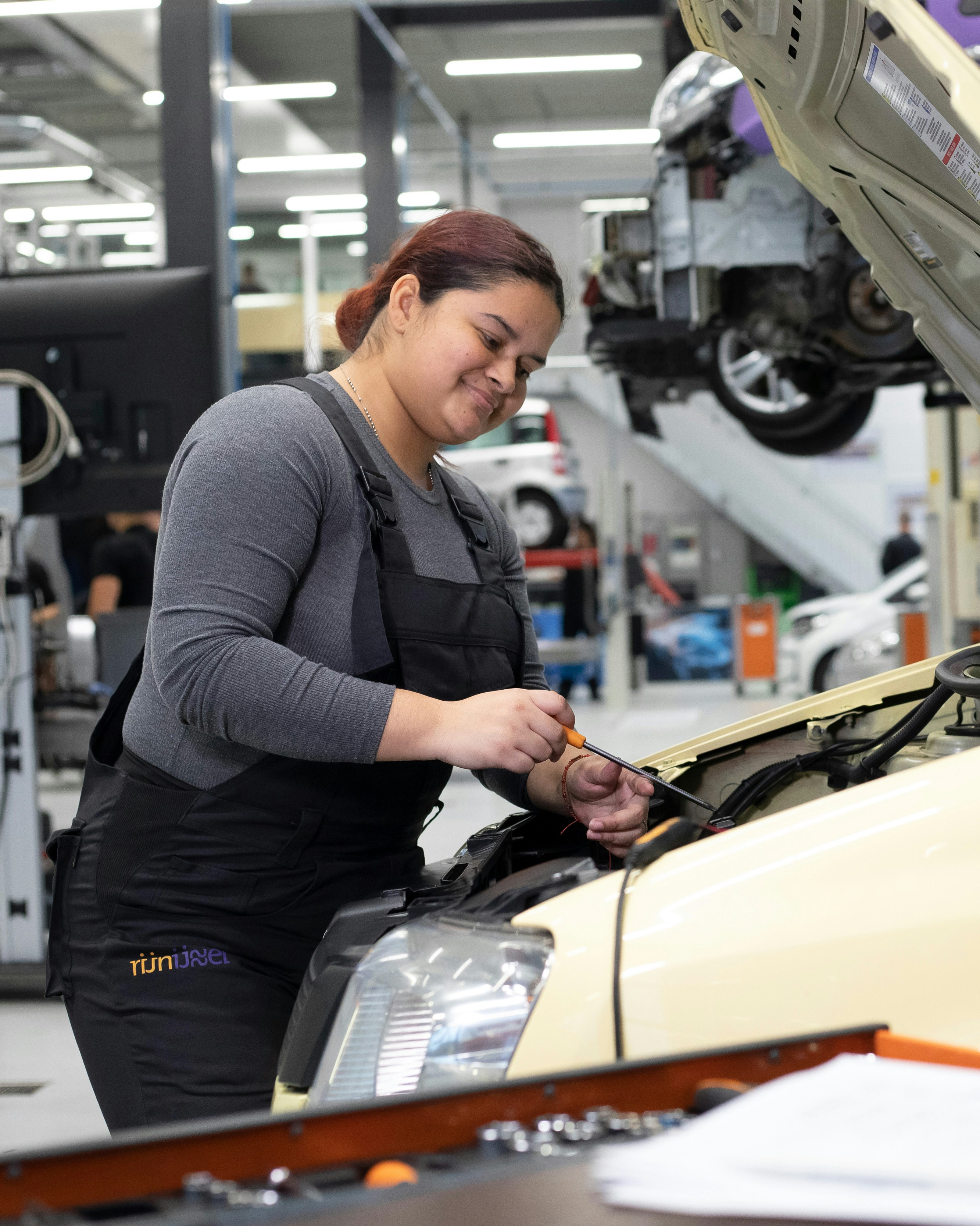 Student is bezig onder motorkap van een auto