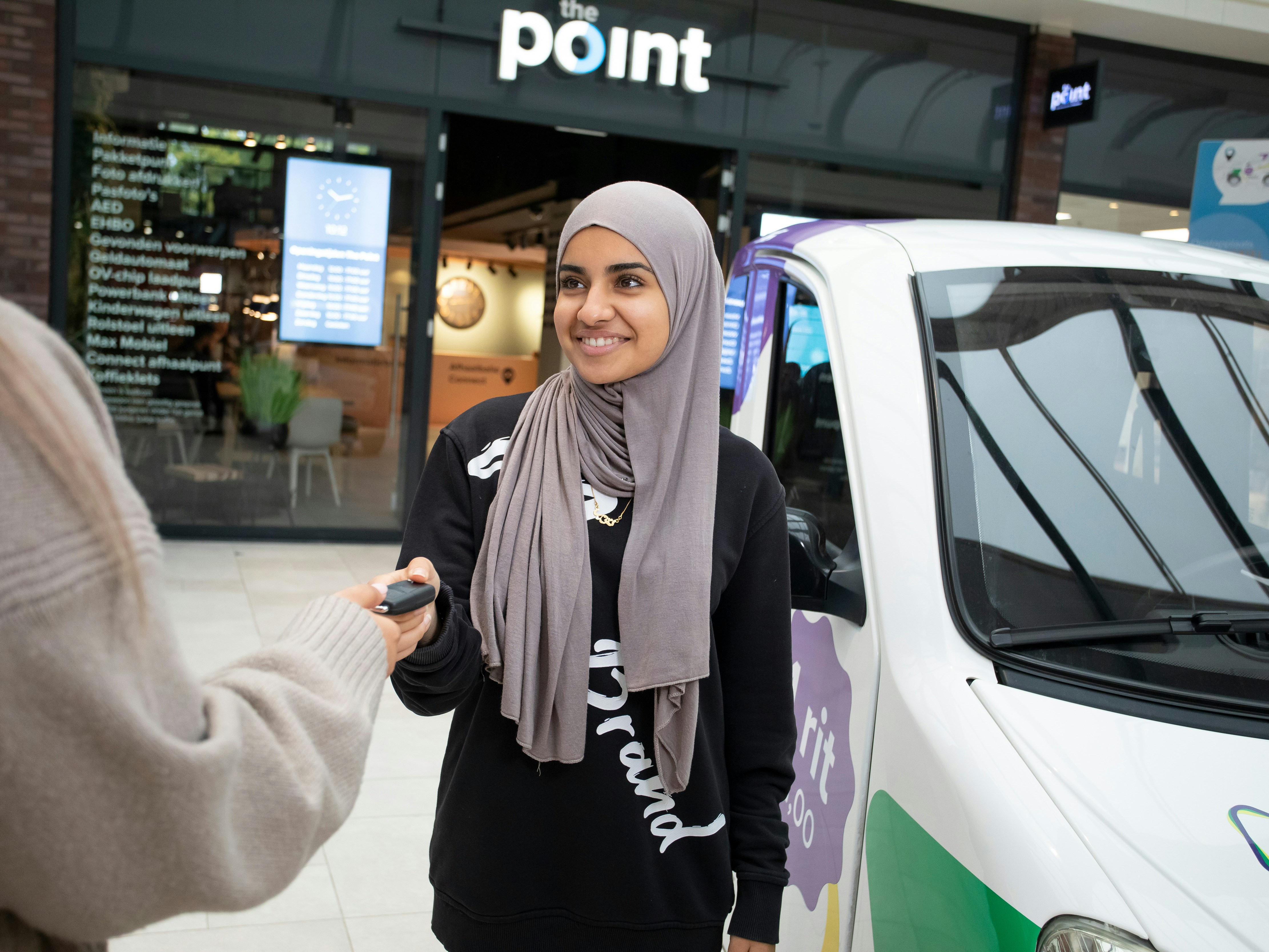 Student geeft een autosleutel aan iemand