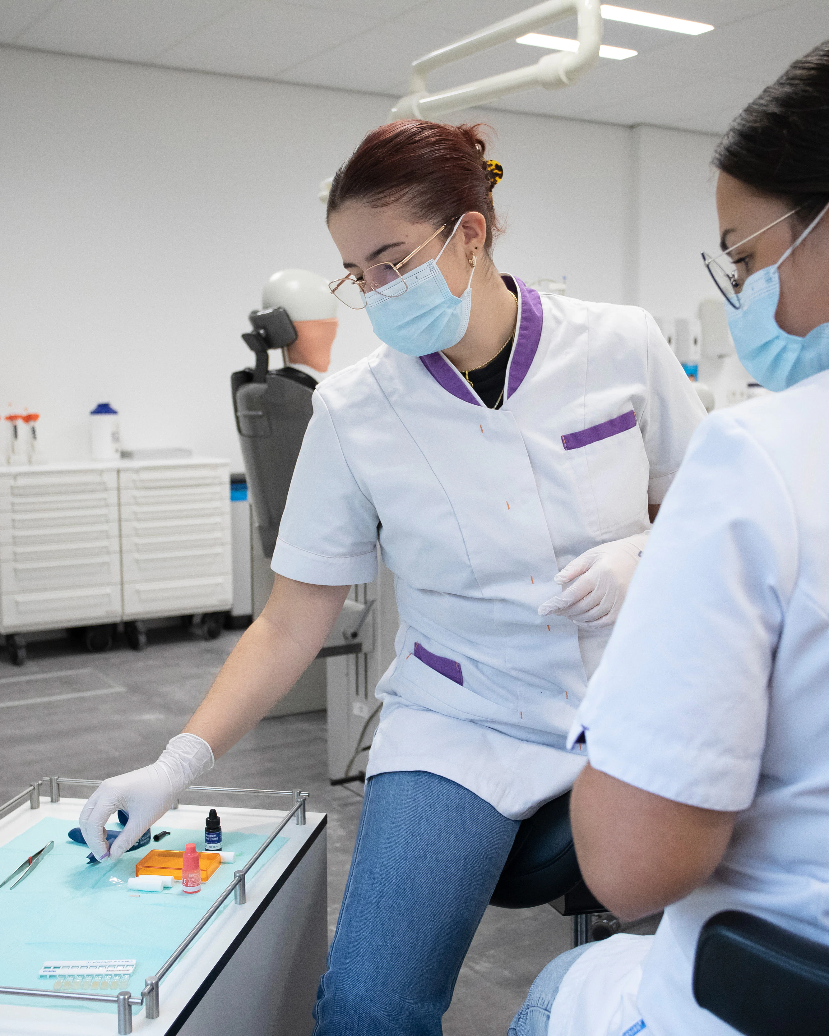 Twee studenten kijken naar een tafel waar gereedschap voor een tandarts op ligt